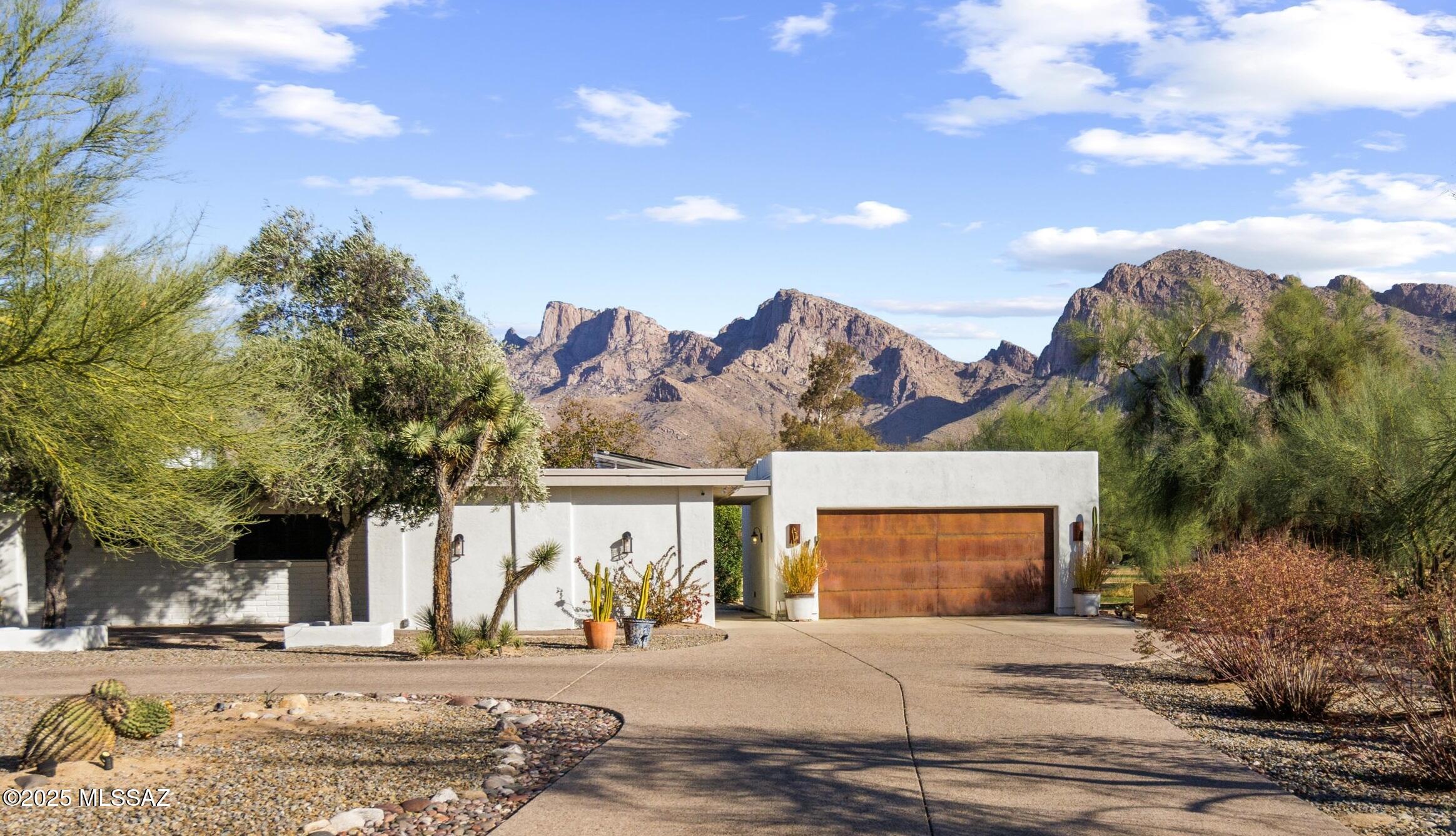 Seller will accept or counter offers between $1,195,000- $1,235,000. Discover a stunning and beautifully renovated MID-CENTURY MODERN gem in the prestigious Oro Valley Country Club! Originally built in 1959, this home boasts OWNED SOLAR on a .79-acre lot, showcasing one of the original residences in Oro Valley's most coveted community. Ideally situated with expansive outdoor entertainment areas and a sparkling pool, the property offers lush golf course frontage along the 2nd tee and breathtaking views of the Catalina Mountains. Spanning nearly 3,600 square feet, this remarkable home features a luxurious master suite with an expansive closet and private bonus space, complemented by 3 additional guest bedrooms and 4 newly designed, elegant bathrooms. The gourmet kitchen has been meticulously remodeled, offering commercial grade oven, pendant lighting, custom hood, designer backsplash, waterfall quartzite island and sub zero appliances. Adding to its features, the property includes a spacious bonus room with a separate entrance, perfect for a home office, studio, multi-generational living or guest suite. The oversized 2-car garage, is expanded depth, provides ample storage for two or more cars or additional space for a golf cart, completing this extraordinary residence. Two bonus areas not included in the square footage bring the livable area to over 4000 sq feet! Do not wait, schedule your showing today!
