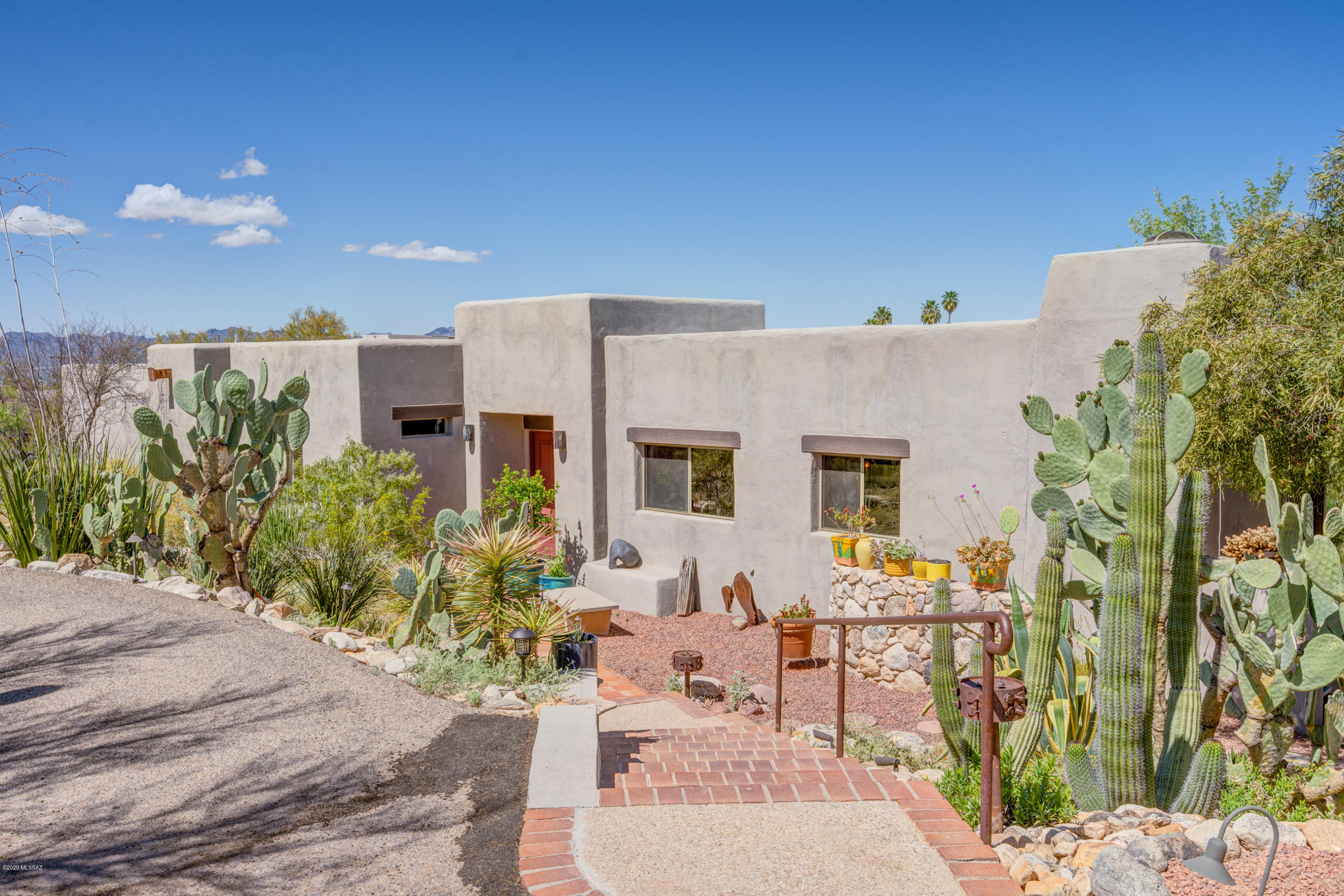 Feel drawn into nature in this tranquil and very private 1.3 acre natural desert setting in central foothills. Enjoy unobstructed Catalina mountain views, gorgeous sunsets, and numerous saguaros! This well-maintained home has durable brick floors in living areas and beamed ceilings originating from Mt. Lemmon. Kitchen has solid cherry cabinets and expansive granite countertops. Hearth room off kitchen features a unique fireplace. Large bedrooms have concrete floors and lots of storage—4th bedroom has 2 private entrances. Master bedroom features a fireplace, slate floors and patio entrance. Multiple outdoor spaces for entertaining and relaxing. Recent improvements: garage floor re-coating, roof re-coating (with warranty) and pool deck resurfacing. Two quality rainwater harvesting tanks. (tank capacity of 1000 gal. and a 500 gal.) This "old foothills" neighborhood offers great walking areas and access to shopping and schools. Don't miss this opportunity to live in what many have said is the "best neighborhood in the foothills"!