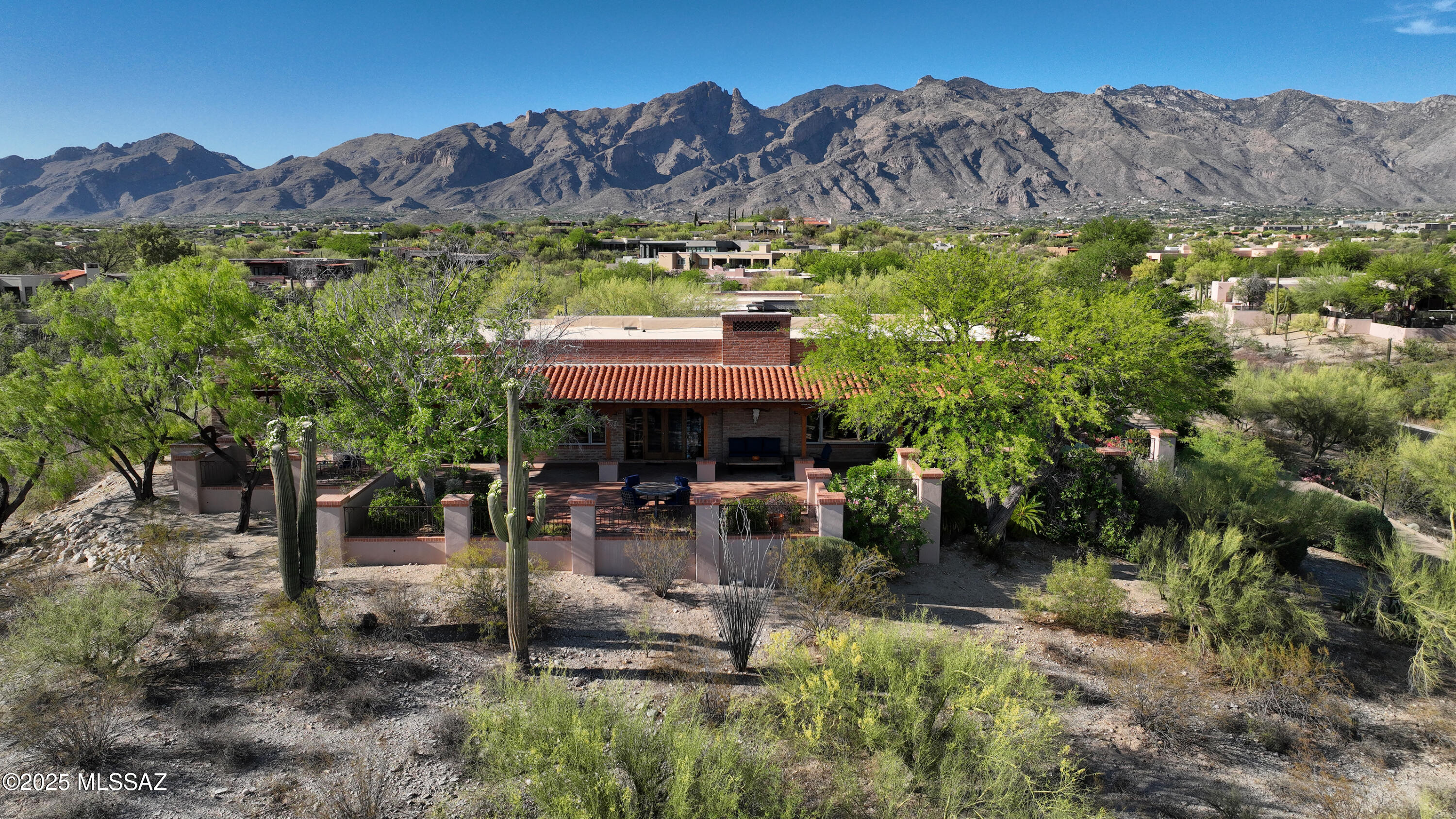 Welcome to a truly extraordinary opportunity in prestigious Catalina Foothills! This is your chance to own a private estate that embodies the essence of Southwest elegance, privacy, and versatility. Step inside through a charming brick courtyard with fountain, an enchanting prelude to the beauty that lies within. As you enter, your gaze will be drawn to dramatic wooden ceilings with vega beams, a hallmark of true Southwestern craftsmanship. The expansive great room boasts breathtaking views of the distant mountains and sparkling city lights, all enjoyed from the warmth of a spacious and grand place to spend time with your guests and loved ones in front of the statement stone fireplace. This room could easily be considered the heart of the home. The kitchen is rich in charm and offers excellent flow, ideal for the home chef to customize and enhance. The primary suite is a private retreat with oversized rustic wooden doors, its own fireplace, and inspirational views. The en suite bathroom features unique character throughout, from its spacious walk-in closet, dual vanities, soaking tub, and walk-in shower, providing the perfect mix of function and relaxation.

Don't miss the office, with a north-facing picture window framing mountain views.  Split on the other end of the home are two additional en-suite guest bedrooms.

The back patio is the crown jewel of the main home and a captivating space designed for unwinding and soaking in the uninterrupted panoramic views and city lights that make Tucson's Catalina Foothills so sought after. It's no wonder the current owner chose to purchase and preserve the two adjoining vacant lots, ensuring peace, privacy, and unobstructed vistas for years to come.

Properties like this seldom come to market, especially in such a desirable and prestigious community.  Schedule your private tour today and experience firsthand what makes this one-of-a-kind Catalina Foothills estate so exceptional. Don't miss your chance to own a piece of Tucson luxury that truly stands apart.