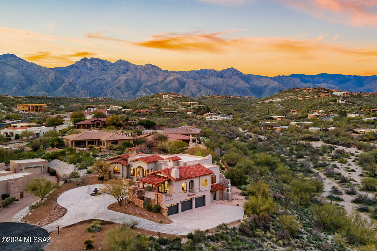 This exquisite custom home offers both city and mountain views from nearly every vantage point. A delightful modern twist on the Mediterranean style, warm finishes and updated fixtures makes this a turnkey luxury sanctuary in the Catalina Foothills. Arched wood windows and solid Alder doors open to pristine indoor and outdoor spaces. Custom cabinetry, quartzite counters, stunning light fixtures and terracotta style floors throughout. The gracious open floor plan offers split bedrooms and flexible areas for living, dining, and entertaining. This home offers numerous bespoke details such as beamed and coffered ceilings, plantation shutters, as well as three indoor and one outdoor fireplace. The gourmet kitchen boasts a 48-inch refrigerator, six-burner gas stove, a large island and peninsula making this an entertainers dream. Enjoy sparkling city lights from the primary suite with a beautifully remodeled bathroom. Dual vanities, coved ceilings, custom shower, and an elegant modern soaking tub. Additional bedrooms and baths on both levels provide ample space for family members or guests. For ultimate versatility, the lower level features a self-contained apartment with a separate entrance complete with a kitchenette, living area, bedroom and bath; this space offers endless possibilities. Convenience is key with the inclusion of an elevator, ensuring effortless access to both levels of the house. A 3-car garage provides plenty of storage space for vehicles, hobbies, and outdoor gear, while a professionally landscaped yard offers a serene outdoor oasis for relaxation and recreation. Sprawling brick patios, turf lawns, and both mountain and city facing porches create year round delight. This exceptional residence combines luxury, comfort, and convenience in one unparalleled package. Seller is a licensed real estate agent in Arizona.