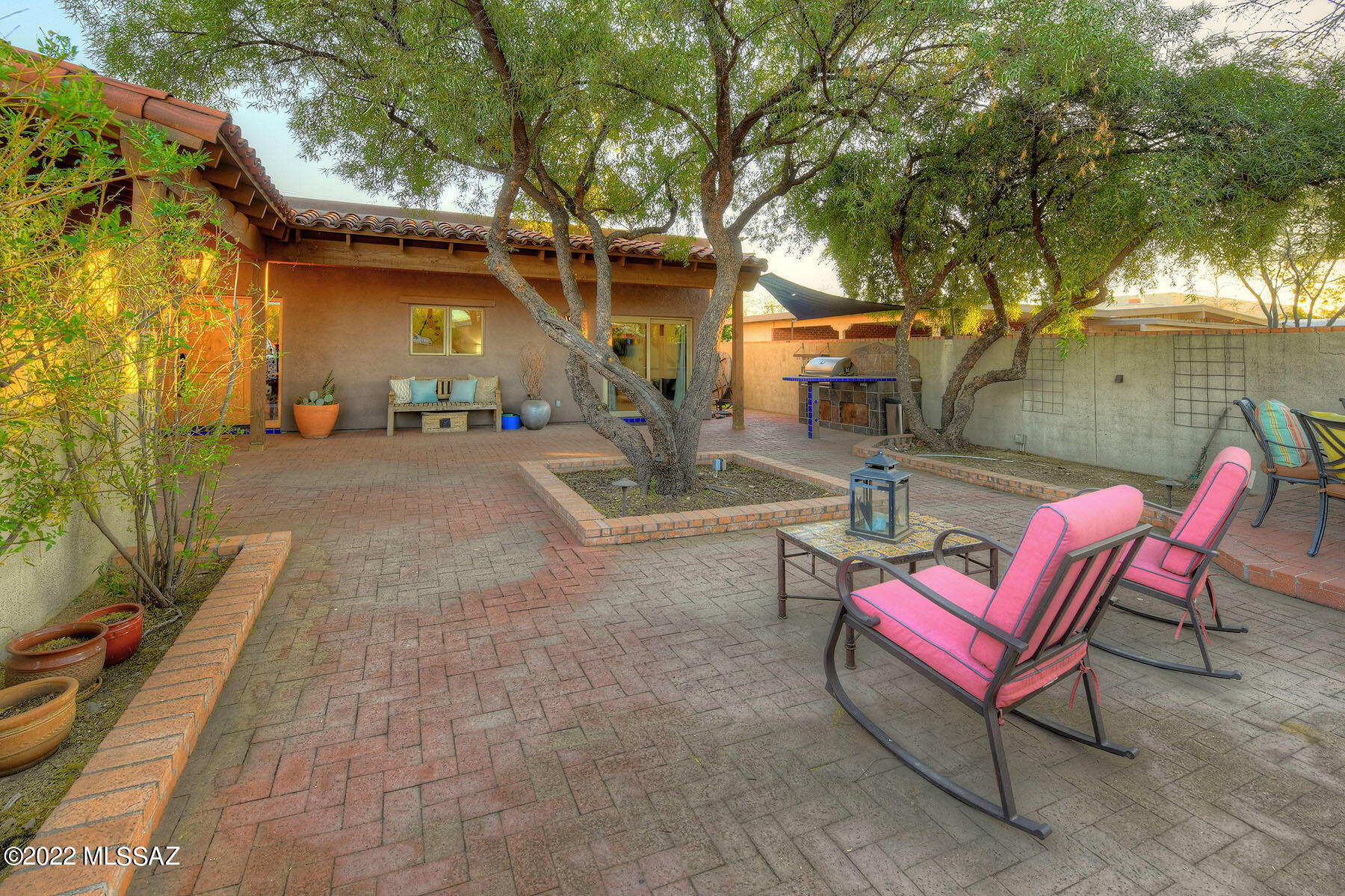 Live in Historical Sam Hughes Community, conveniently located just minutes from the UofA, golfing, shopping, restaurants and more. This remodeled home speaks quality and luxury including large gourmet kitchen with custom cabinets, granite countertops, and island. Welcoming living room with adobe beehive fireplace. Double doors open to a spacious primary bedroom with exquisite en-suite bath with soaker tub and separate entrance to back yard. A guest room with full bath and entry from outside. Plus 2 more bedrooms and a den. All surrounded by your own private Tucson oasis themed yard with decorative brick and tile walkways, built-in southwest Ramada, custom bar, BBQ, maturely grown trees and more. Too much to list. See additional list of amenities.
