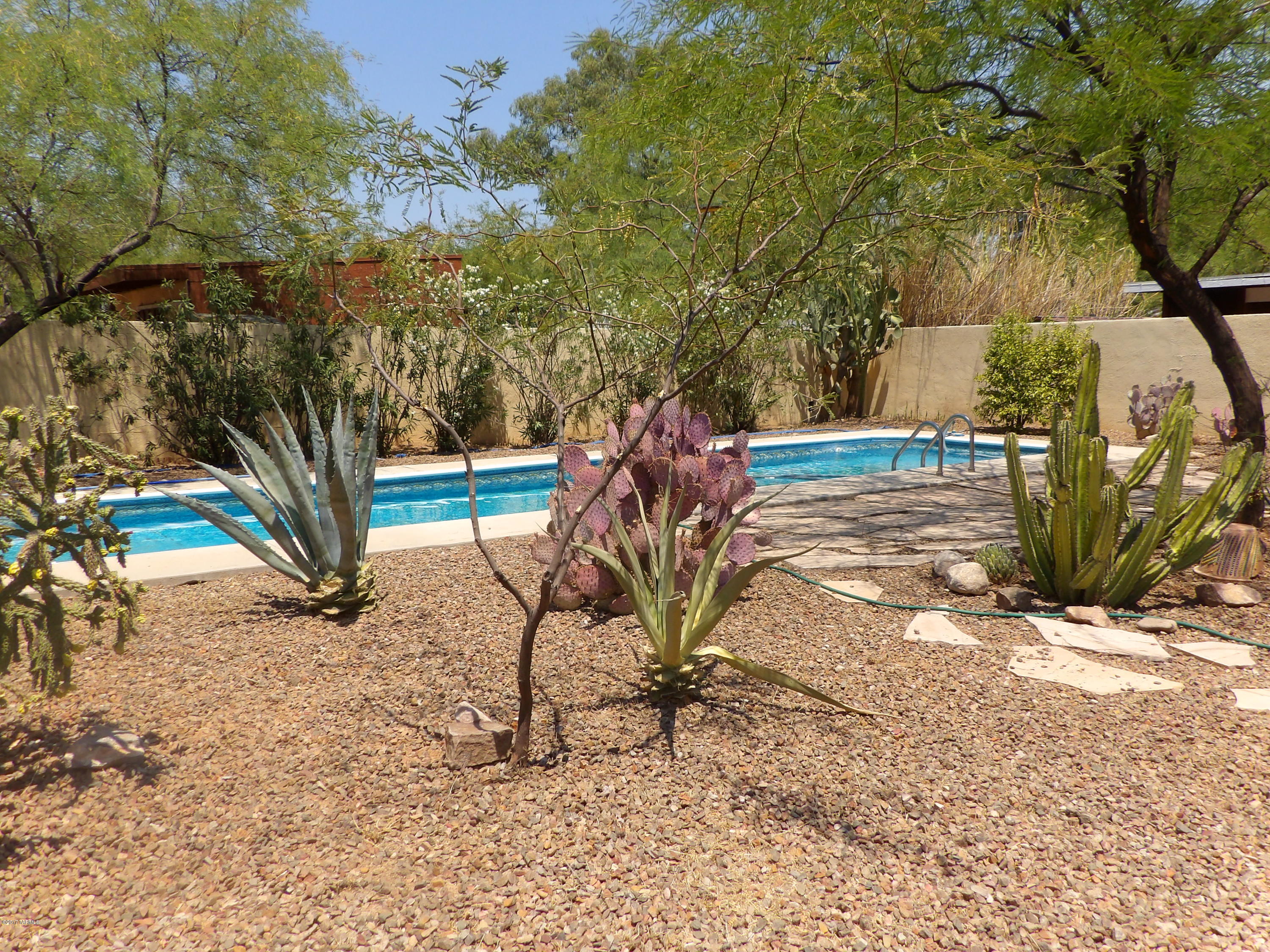 Located in central Tucson, this lovely 1950's bungalow has exactly what you're looking for. Small and quaint let's call it home. Large fully landscaped front and desert rear yard surrounded by a block wall and wrought iron fence and gate. Back yard features a smaller sized lap pool, 4 feet deep which means lower maintenance. Enjoy your day or night in a relaxing outdoor side patio garden that features a small waterfall. Back yard also includes a covered patio connected to a large workshop/laundry room. Saltillo tile floors throughout. 1 bedroom and office or 2 bedrooms, your choice! Some deferred maintenance, bring your tools. Patching, paint and some updating will make this the perfect home. Priced accordingly. Come check out this property today!