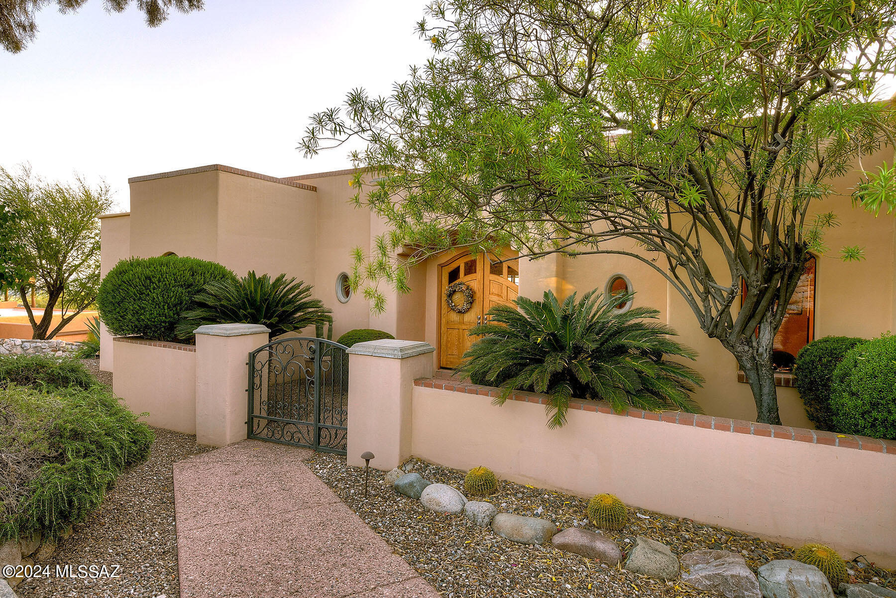 Welcome to desirable, gated Foothills II community, nestled at the top of Alvernon, close to the Finger Rock Trailhead. This stunning 3-Bedroom +Den, 3-Bath home spans 3,171 square feet on a spacious .89-acre lot. Stepping inside the dramatic foyer, discover immaculate Saltillo & Hardwood flooring throughout. The gourmet kitchen boasts a gas cooktop, granite-clad island,  solid wood cabinetry, a breakfast bar plus spacious eat-in area with patio access. The Living area is bathed in natural light from clerestory windows while offering access to a covered patio, pool, spa, and stunning 180-degree mountain & sunset views. The Primary suite also overlooks the serene patio and views. Its luxurious and beautifully appointed bathroom features separate vanities, walk-in shower, See the More tab. plus a soaking tub. Guest rooms on the north end ensure privacy for all. Enjoy the beautifully landscaped backyard, featuring several sitting and entertaining areas, including an outdoor built in BBQ Grill & cooktop. The Dining & Living Rooms share a double-sided fireplace with a striking concrete surround, perfect for cozy evenings. This home offers a perfect blend of elegance & comfort in a prime location.