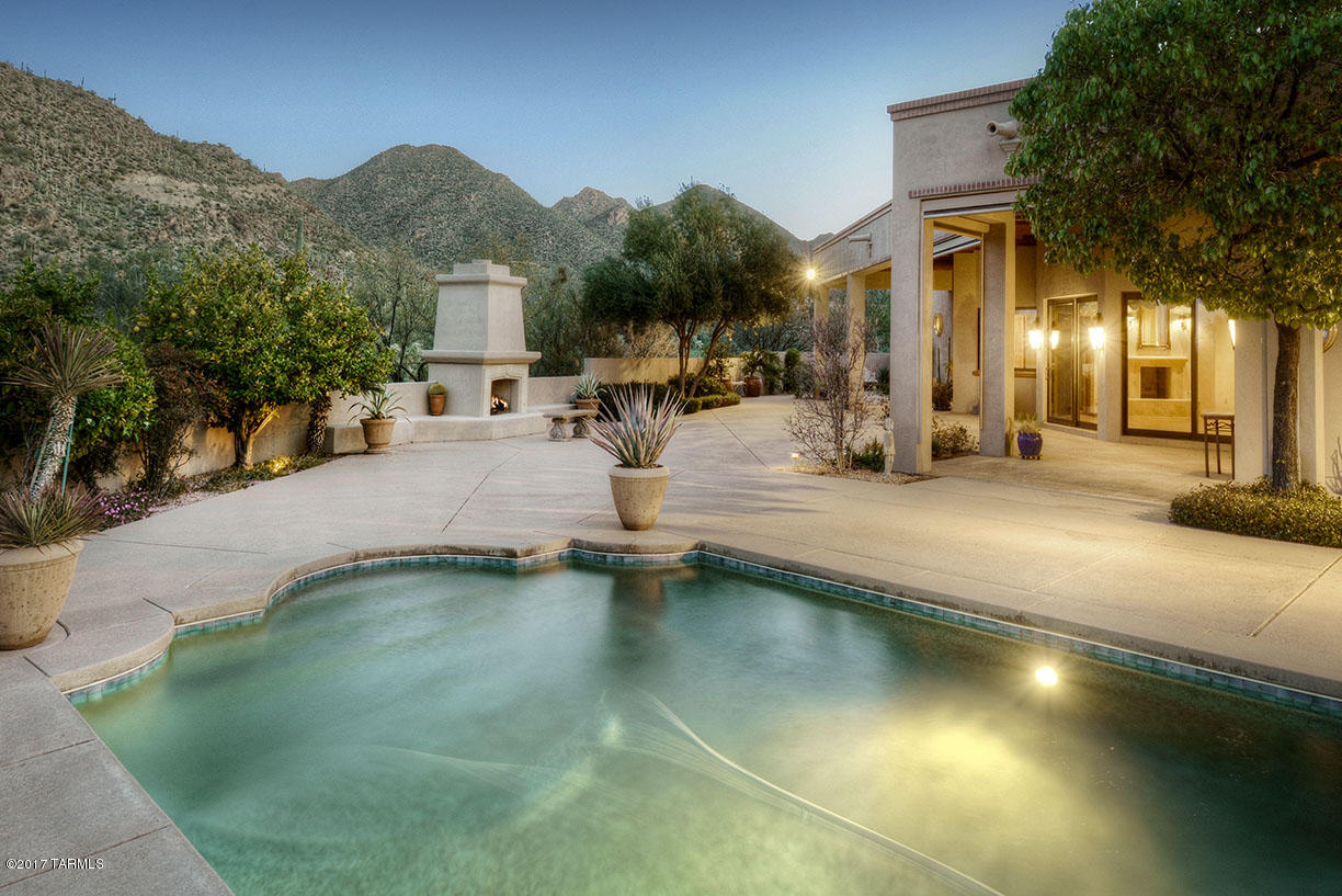 Gorgeous masonry Mike Wachs custom home, perfectly sited on a great lot specifically chosen for it's view corridor and ez access within the Canyon. QUALITY & VALUE are UNBELIVEABLE; appraised at $1.6m in late 2015, this incredible property couldn't be replicated at the current price! Outside, sweeping porches, flowering trees, & majestic fireplace form a perfect setting for entertaining or just enjoying the mountain views & twinkling lights of Marana; Inside, wide windows frame the mountain views, a beautifully appointed entertainer's kitchen opens to a warm, comfortable family room; gleaming wood floors and rich textures throughout, luxurious office/den, grand living room w/bar, gracious master suite w/his & hers dual baths & an adjoining fully equipped exercise room. See video & photos!