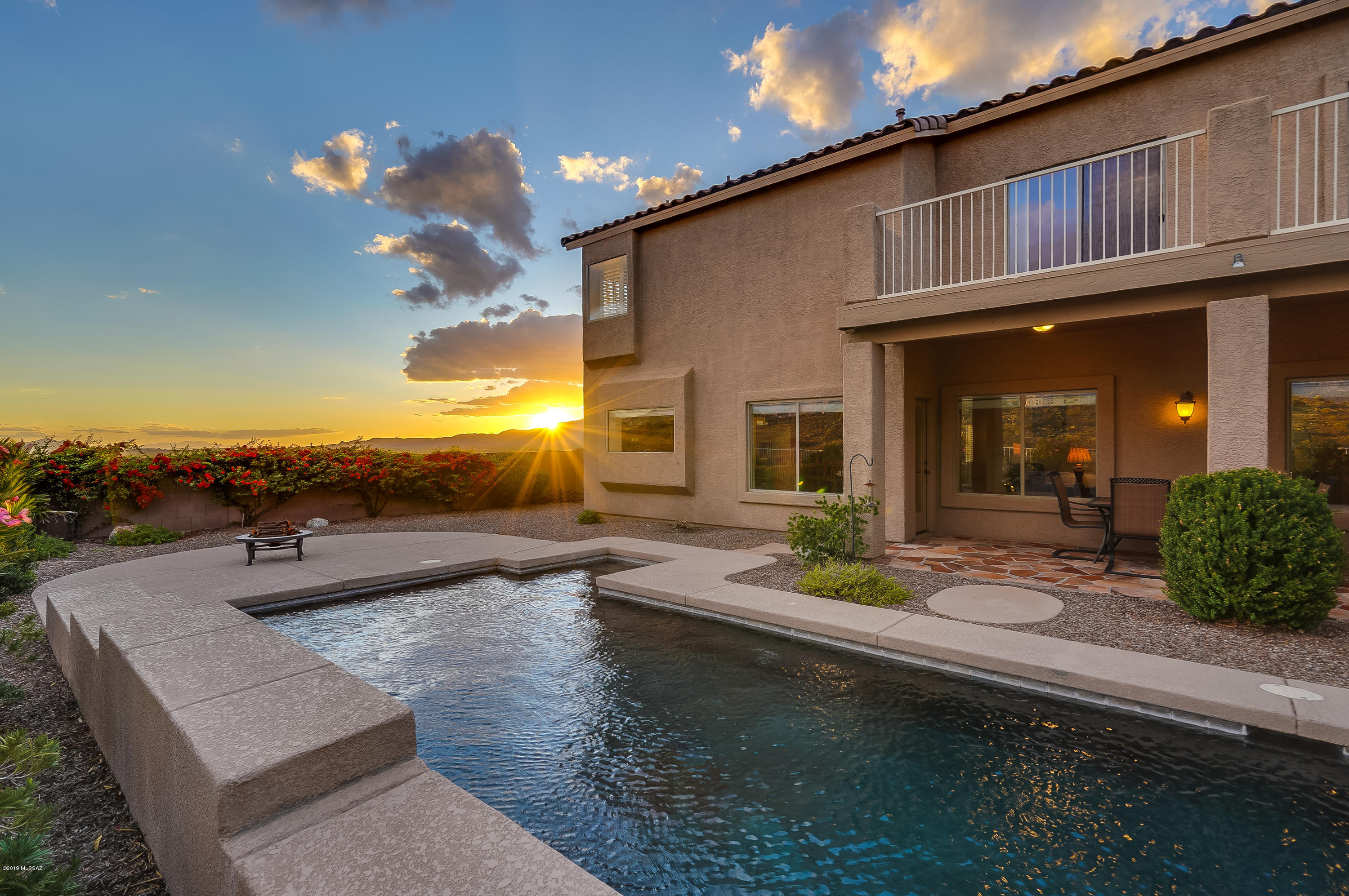 Refined Elegance with a View! A stunning entrance opens to a sweeping wrought iron staircase in the center of the home. An adjacent expansive living room w/fireplace allows for separate entertaining spaces. Just beyond the formal dining room is a grand kitchen w/ solid surface counters, stainless appliances & views that abound from nearly every window. The adjoined great room, w/ second fireplace & dining nook, leads out to a spectacular backyard w/ plumbed natural gas BBQ, covered patio & those Mountain (& SUNSET) views! The self-sweeping pool has a separate pump for the waterfall features & is a beautiful centerpiece to a rugged backdrop. The master bed is equally large & opens to a lovely bathroom & walk-in closet. A downstairs bedroom is private for guests or that quiet home office.
