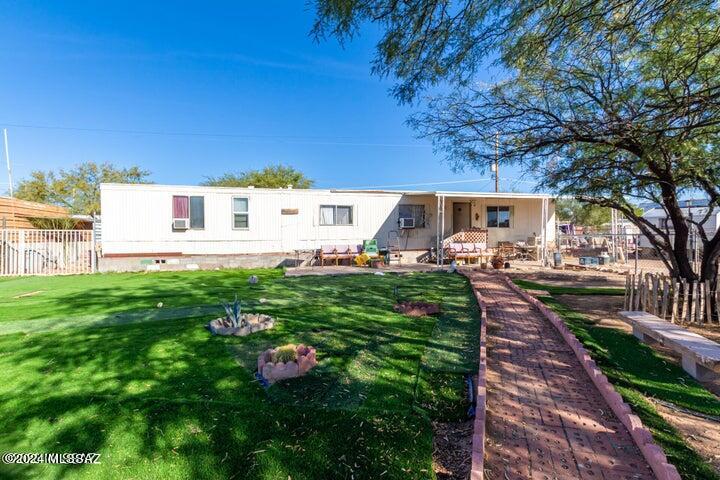 ***MOVE IN READY***  manufactured home nestled on a cul-de-sac! A fully fenced property, displaying a front porch to relax and a large front yard with artificial turf. Enter to be greeted by a formal living room! Continue onto the eat-in kitchen to find built-in appliances, ample wood cabinetry, & a pass-through window with a breakfast bar. Perfectly sized bedroom with two closets & tile flooring! You'll love the extra room unfinished, ideal for a second bedroom, office, workshop, you name it. Discover the spacious backyard, offering a paver patio & two storage sheds!