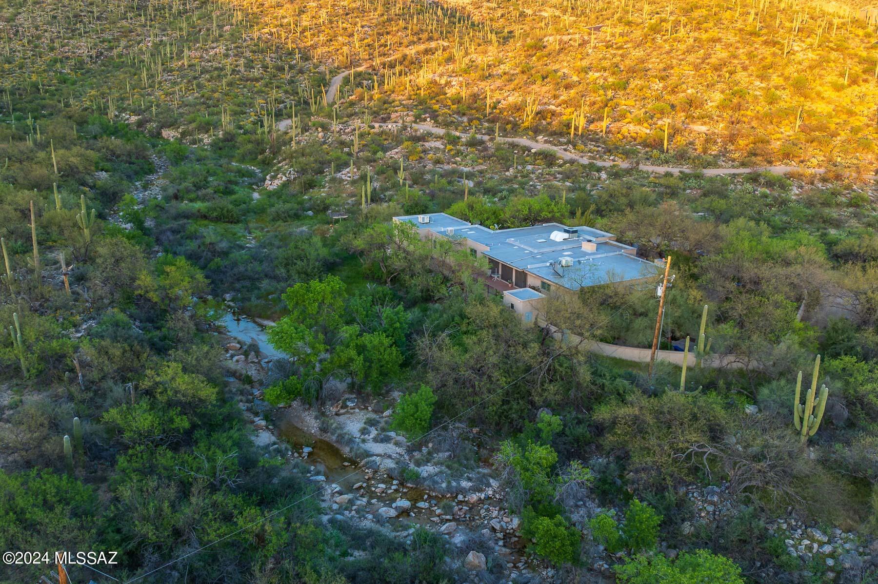 Discover a rare gem in an exquisite desert oasis w/ a seasonal stream at your back door. Nestled against the Molino Creek, this property offers the soothing sounds of running water, complemented by the chorus of birds, crickets, & frogs. Known as a flyway for migratory birds & butterflies, it's truly enchanting.  Experience stunning views of canyons, mountains, & the starry nights. Enjoy the peace & beauty of rural living yet remain conveniently close to city amenities & more. The home boasts solid block & stucco construction, ensuring durability & strength.  The property features spacious interior w/ 4 bedrooms, 3 baths, LG 2-car garage, living & family room & much more. For additional privacy & space, see MLS# 22409320 for the home & an extra 3.31-acre lot. This is a rare opportunity!!
