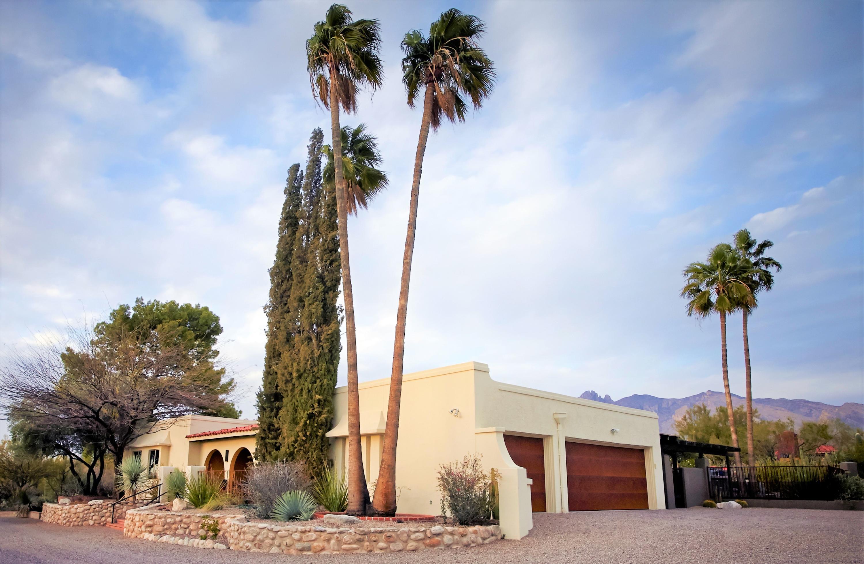 Inspired by their life long travels around the world, the sellers of this magical Foothills home have transformed this quintessential ''Old Foothills'' territorial into a timeless yet modern showplace while still retaining its authentic and classic Tucson charm. Situated on a prime mountain view, cul-de-sac lot in Cat 7, this home offers the new owners a true taste of the beautiful and lush Sonoran Desert Southwest with its amazing array of exotic succulents and rare cactus strategically placed to enhance the natural beauty of the desert landscape. A courtyard entry greets guests and also provides a perfect viewing area to watch the unrivaled & majestic Tucson sunsets. Inside this spacious 3br + den, you will find exposed wood beamed ceilings, natural stone walls, NO interior steps, two newly renovated spa like bathrooms and a gourmet kitchen with soapstone counters, custom cabinets and stainless appliances including a gas range overlooking the sparkling pool area. In the dining room, you are welcomed by a built in buffet/wet bar, Pella sliding glass doors leading to the rear terrace and an unobstructed view of Finger Rock. The living room features a gas fireplace, custom wall of built-ins to displace ones collections and ample wall space for large art. A spacious family room/den also features a gallery display wall and gas fireplace. The luxurious master suite features a new bathroom w/floating vanity, walk in shower and walk out Zen garden. The enchanting backyard is an entertainers dream with multiple gathering spaces. An expansive wrap around covered porch leads to an outdoor kitchen, raised seating area with an artistic fireplace to view the city lights, intimate patio with a fountain off the master with views of the Catalinas and a cozy alcove overlooking the pool.  An oversized 3 car garage w/rusted metal doors provides additional storage, workshop and opens to a gravel circular driveway w/additional space for parking. Low HOA in one of the most desirable neighborhoods in Tucson! This home offers its next owners an excellent & convenient Foothills location, good bones that have been tastefully updated and a home that exudes a great energy and loads of charm!