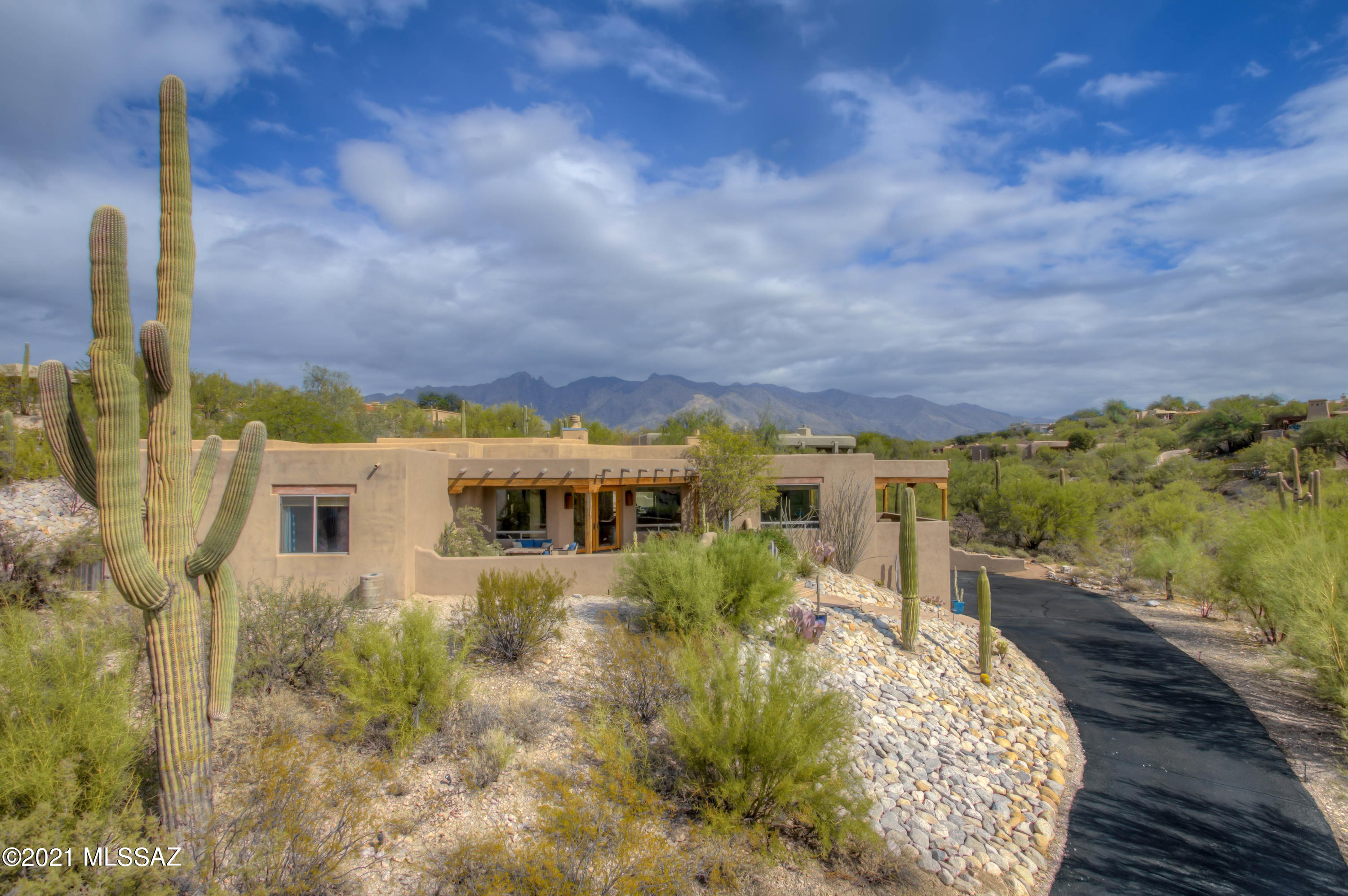 Tucson resort living with indoor/outdoor living spaces in custom crafted home nestled within prestigious manned gated Hacienda del Sol Estates - Amazing City views. Elevated hot tub atop the cascading waterfall above the refreshing pebbletec pool. Entertain on expansive mult covered patios & newer outdoor kitchen. The chef will love the massive kitchen - gas cooktop & SS appl. tremendous island w/ built-in wine rack. Timeless rustic elegance inc. sculptured vega beamed ceilings, mult custom interior rock finishes, 3 masonry fireplaces, concrete & solid wood flooring, oversized 3 car garage + lg wkshp. Entire living area on 1 floor w/ gorgeous views out of every window. Healthy Foothills living - Minutes away from Tucson Loop Trail, Farmer's Mkt, best restaurants & shopping. Dist 16 Schools