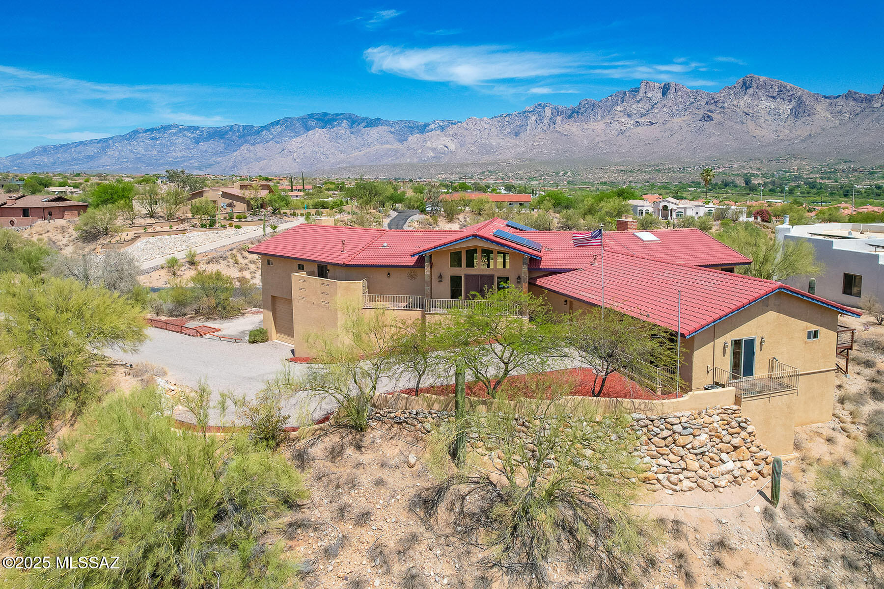 SPECTACULAR 360-DEGREE VIEWS encompassing panoramic mountain views, Tucson & Oro Valley city lights, plus views of 'A' Mountain and Mt. Lemmon. One of 4 original custom homes built at Monte Del Oro in highly revered Oro Valley. This hilltop estate boasts NO HOA, energy efficient SOLAR, oversize 2-car garage plus RV garage with 508 sq ft bonus media/game room, temperature controlled wine cellar and 3/4 bath. Dramatic slate tile entrance flows to an impressive gathering room off main patio with soaring cathedral ceiling and floor-to-ceiling view windows; ideal for entertaining. Beyond lies an open concept family room with wine bar. Gourmet kitchen hosts breakfast bar, stainless appliances including induction cooktop, and 2-way fireplace to outer flex/sunroom accessing large deck. Main home offers 3 bedrooms, 3.5 baths plus 3,615 sq ft to include an Owner's suite with luxury bath, fireplace, dual walk-in closets and main patio access; en-suite bedroom 2 off main patio, guest room with private entry, hall bath and view deck; plus powder and laundry rooms. Newer leach field (2022), HVAC/mini splits (6 yrs), tankless water heater (5 yrs) and roof (11 yrs). Countless additional amenities include granite countertops, extensive Travertine floors and bath surrounds, gorgeous engineered wood plank flooring in formal room and bedrooms, whole house water filtration, dual skylights plus attic fans to draw in outside air, security screen doors on most exterior doors, hallway storage closets, patio misters, BBQ island with sink, green house, newer leach field plus transferable home warranty through November 2029. Don't miss out on this outstanding property with natural desert landscape and phenomenal views!