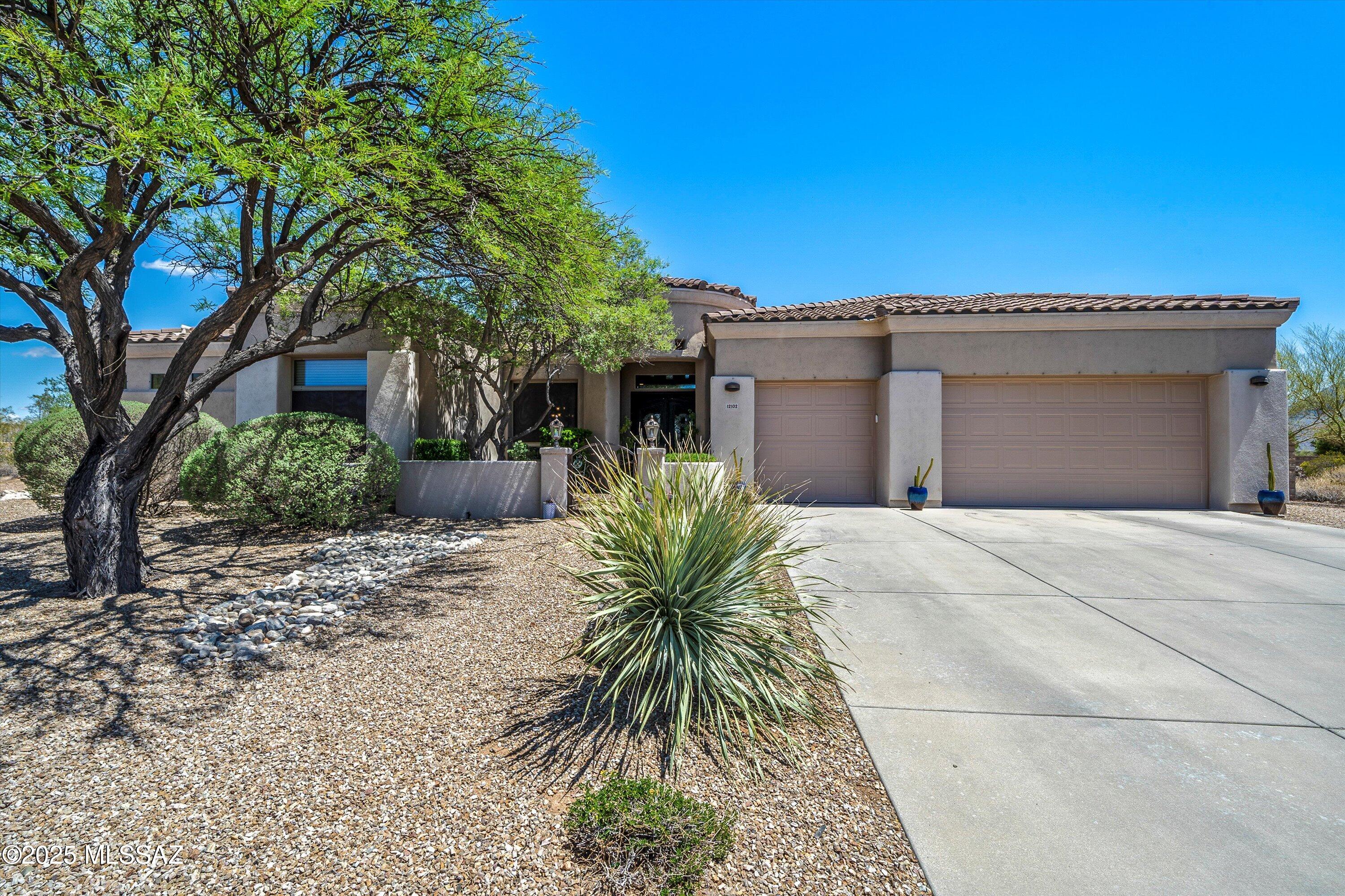 Stunning, gated Oro Valley home with privacy and mountain views. Located on a spacious .89-acre lot, this former model home offers unbeatable views and resort-style outdoor living. Enjoy a PebbleTec pool and spa with a waterfall, built-in BBQ, and putting green—perfect for relaxing or entertaining all year long. Inside, the home features travertine tile, updated plank tile floors, soaring ceilings, inviting electric fireplace, double iron entry doors, oversized windows, and a 4-bedroom, 3.5-bath split floor plan with open living spaces and an extended 3-car garage. The updated kitchen includes quartz countertops, a stylish backsplash, stainless steel appliances, 5-burner gas cooktop, dual ovens, and a breakfast bar. Don't miss this opportunity—schedule your showing today!