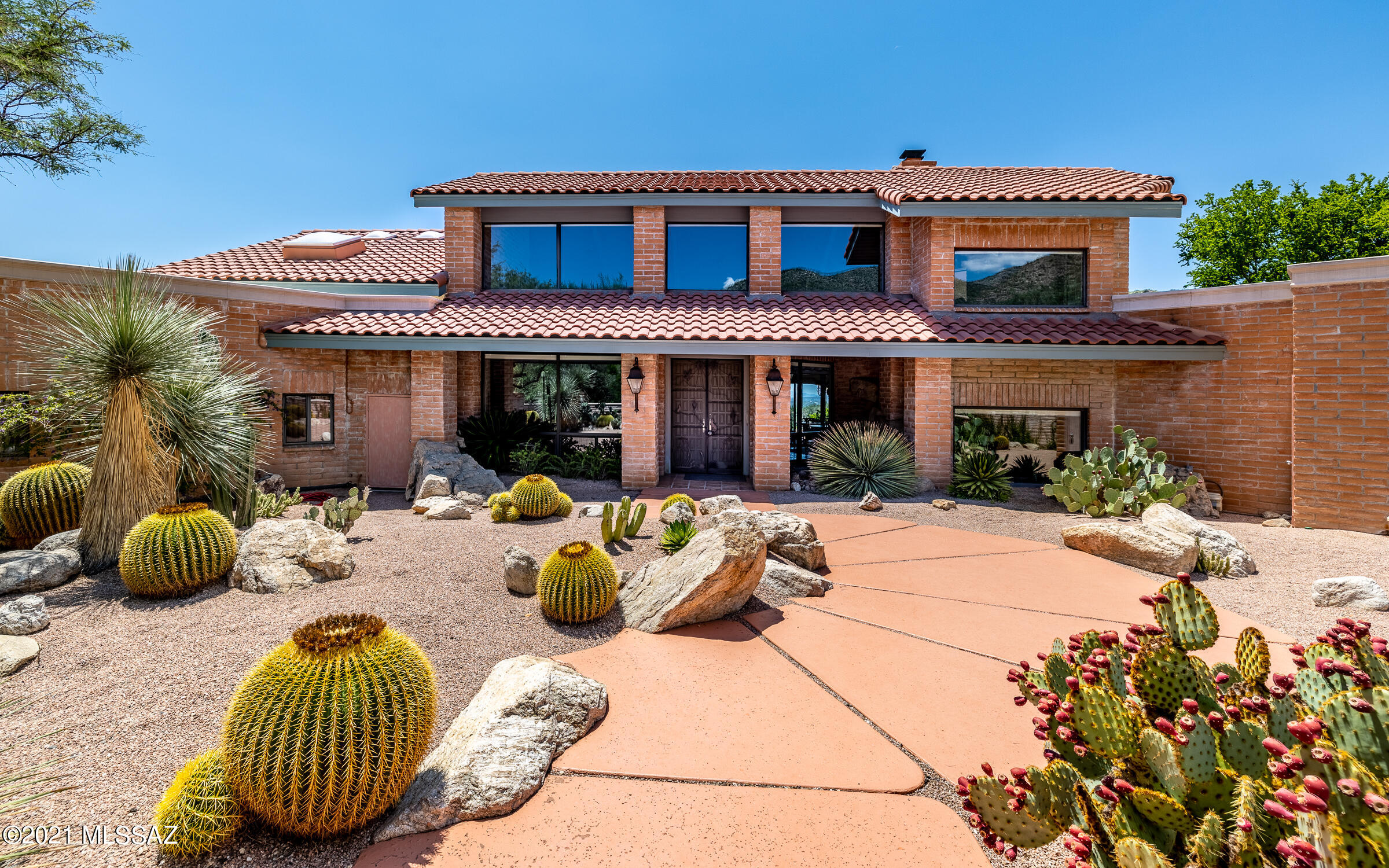 This custom home masterpiece is perfectly sited on 2.5 acres, on a high elevation lot with spectacular panoramic canyon & city views. It borders the Coronado National Forest and is adjacent to a wonderland of swooping canyons, thrilling peaks & ridges, and Saguaro studded hillsides. Enter through a gated driveway leading to two separate parking areas: garage parking & a circular driveway for guest parking. Home includes 4147sf of total living space, including a 541sf casita! The majority of home (94.3% of sf) is ground level and is classified by Pima County as a one story home. Enjoy stargazing, city lights, or the canyon's treasures from your very own upstairs bonus room and view-deck! This home was masterfully designed to allow the indoor & outdoor spaces to blend: the saltillo tile and wooden ceiling beams move seamlessly from the interior to exterior space, visible from walls of windows, allowing your eyes to follow the interior views right on outside to the sparkling pool, spa, terraced flowerbeds, and out to nature's powdery blue skies and miles of desert landscape or city views. Even the mortar washed block that dramatically captivates you from the exterior, shows itself as accented walls throughout the interior. The floorplan is anything but typical, its angled rooms have been crafted to allow the perfect view to filter in from every room of the house while still feeling extremely private. The architect's design incorporates rooms that have built-in seating areas, atriums, planter boxes, and waterfall features that make you feel as though you are constantly part of nature. This home is near Agua Caliente Hiking Trailhead, gifting an open invitation to further explore the outdoors. The gated, custom home community of Redington Ranch has horse facilities, boarding stables, riding trails, clubhouse, pool, lighted tennis courts and even a pond. The functionality and mechanics of the home have also been carefully considered/designed from: being connected to city water and having an additional 900 gallon water holding tank with a plumbing pressure booster; plants are connected to irrigation on timers; a 1000 gallon propane tank supplies the pool and spa; the pool equipment has been replaced (2019) and majorly updated with automation that runs off phone app (or manually); the pebble tech pool and spa are on autofill; Sentricon termite bait stations provide a perimeter of protection; the garage has extra storage capacity with two storage rooms and a 400 bottle wine fridge. This home is a work of art, designed with nature in mind, and the seller has focused on many of the home's mechanical and function items: roof, HVAC, pool & spa, and flooring/ceiling of the casita. Updating the paint or some of the cosmetic features are for the new owner to create, but the majority has been skillfully crafted and pridefully maintained. Please see the FULL upgrade/feature sheet attached, along with a 2-D AND 3-D floor plan, invoices of recent work, and enjoy the virtual tour with drone footage!!