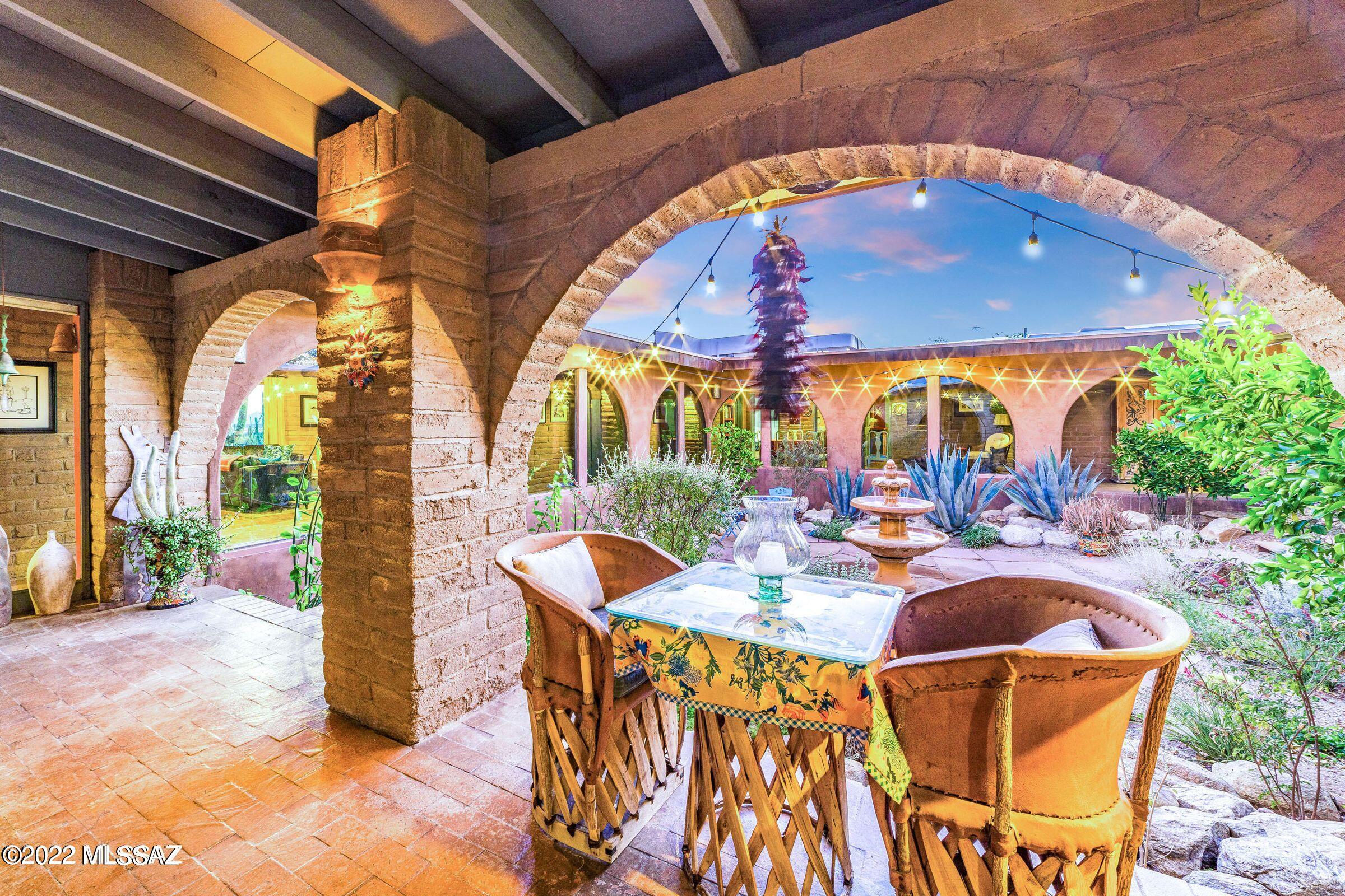 Original sunbaked adobe hacienda-style home with 7 bedrooms, 5.5 baths features over fifty arches and includes entryways with vaulted brick ceilings, beautiful interior arches, handpainted doors, a central courtyard with fountain, and 5 acres of majestic saguaro-studded Sonoran Desert to explore. Hand- made ceramic lights are found throughout while the Viga and Latilla ceilings, brick floors, and brightly patterned Talavera tile further enhance the old-world charm. Kitchen has new refrigerator, dishwasher, luxury gas stove with vent, and island complemented by original Talavera tile countertops and Saltillo floors. Kitchen window overlooks walled second courtyard with meticulously detailed saltwater pool and spa with waterfall. Main residence has large Primary bedroom with walk-in closet