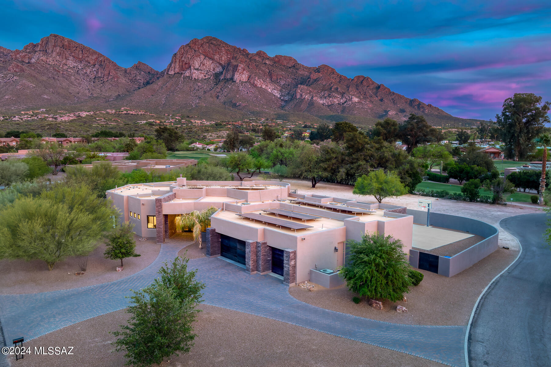 Seller is accepting showings and welcomes back-up offers! Stunning luxury residence situated within the esteemed Oro Valley Country Club on a spacious 1.47-acre lot! Crafted by Copper Canyon Homes, a distinguished custom homebuilder in Oro Valley, this expansive 3830 sqft abode boasts a prime location bordering the golf course and captivating views of the Catalina Mountains. Its well-conceived layout ensures privacy for all occupants, whether family or guests, with a split bedroom arrangement. The interior design offers versatility, effortlessly transitioning between contemporary and traditional aesthetics to suit your personal style and decor. Throughout the home, you'll find exquisite wood-look porcelain tile flooring, complemented by knotty Alder interior doors, Pottery Barn lighting fixtures, and Maple Onyx cabinetry. The heart of the home is its open living area, accentuated by floor-to-ceiling windows framing the majestic mountain vistas, a tray ceiling with rustic beams, and a striking stacked stone fireplace with a rough-edge slate capped hearth. The chef's kitchen is a culinary haven, equipped with a walk-in pantry, ample cabinetry featuring soft-close drawers, granite countertops, a farmhouse sink, a gas range, and custom backsplash. A sunlit breakfast nook adjoins the kitchen, while formal dining is elevated by a chic chandelier and tray ceiling. Guests can indulge in a luxurious bath featuring a backlit mirror, subway tile backsplash, and a lavish custom-tiled walk-in shower. The primary suite exudes serenity, offering access to the patio and a spa-like ensuite with dual granite vanities, a soaking tub, and an oversized walk-in shower. Across the home, two guest suites with private baths and a versatile media room await, adorned with custom barn doors. Outdoor living is equally enticing, with a spacious covered patio providing dining and lounge areas, ideal for savoring the breathtaking Catalina views. The expansive lot offers potential for a pool and currently features a walled faux grass area with a basketball court. This exclusive community, nestled near the Canada del Oro, boasts a rich history and unparalleled natural beauty, with a private golf course and picturesque streets. Conveniently located near Oracle Road and the scenic "Loop," residents enjoy easy access to amenities, including shopping, dining, parks, and recreational facilities, making this residence a coveted retreat in Oro Valley.