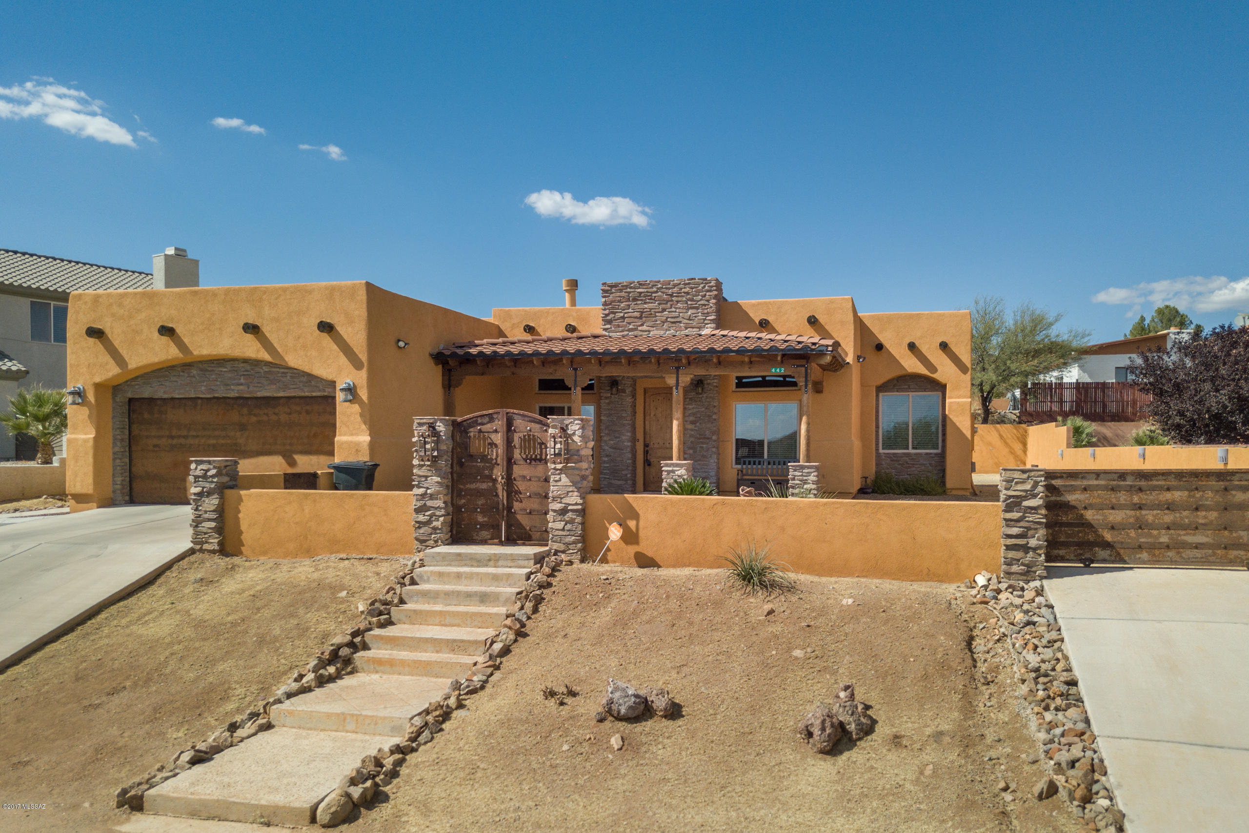 Immaculate custom built home situated on an exceptional lot in coveted Eastside Rio Rico Subdivision! This beautiful property features a spacious four bedroom/three bathroom split floor plan, huge two car garage, family room, living room with fireplace, soaring eight foot doors, travertine flooring in common areas,  wood flooring in rooms, canned lighting, custom paint, surround sound system, and laundry room! Pristine kitchen includes premier stainless steel appliances, electric range, granite counter-tops, breakfast bar, ample counter-top space, and dining area. Master quarters include walk-in shower, spa bathtub, dual vanities, transitional archway, and large walk-in closet. Front courtyard entryway boasts gravel landscaping, metal gate access, established vegetation, ...(see more) ...side gate access, premier lighting, and covered tile front porch. Private side and back yards features low maintenance imitation grass, covered tile back patio, storage shed, retaining way, and side entry/walk ways! Pride of ownership at its finest, this home will not last!