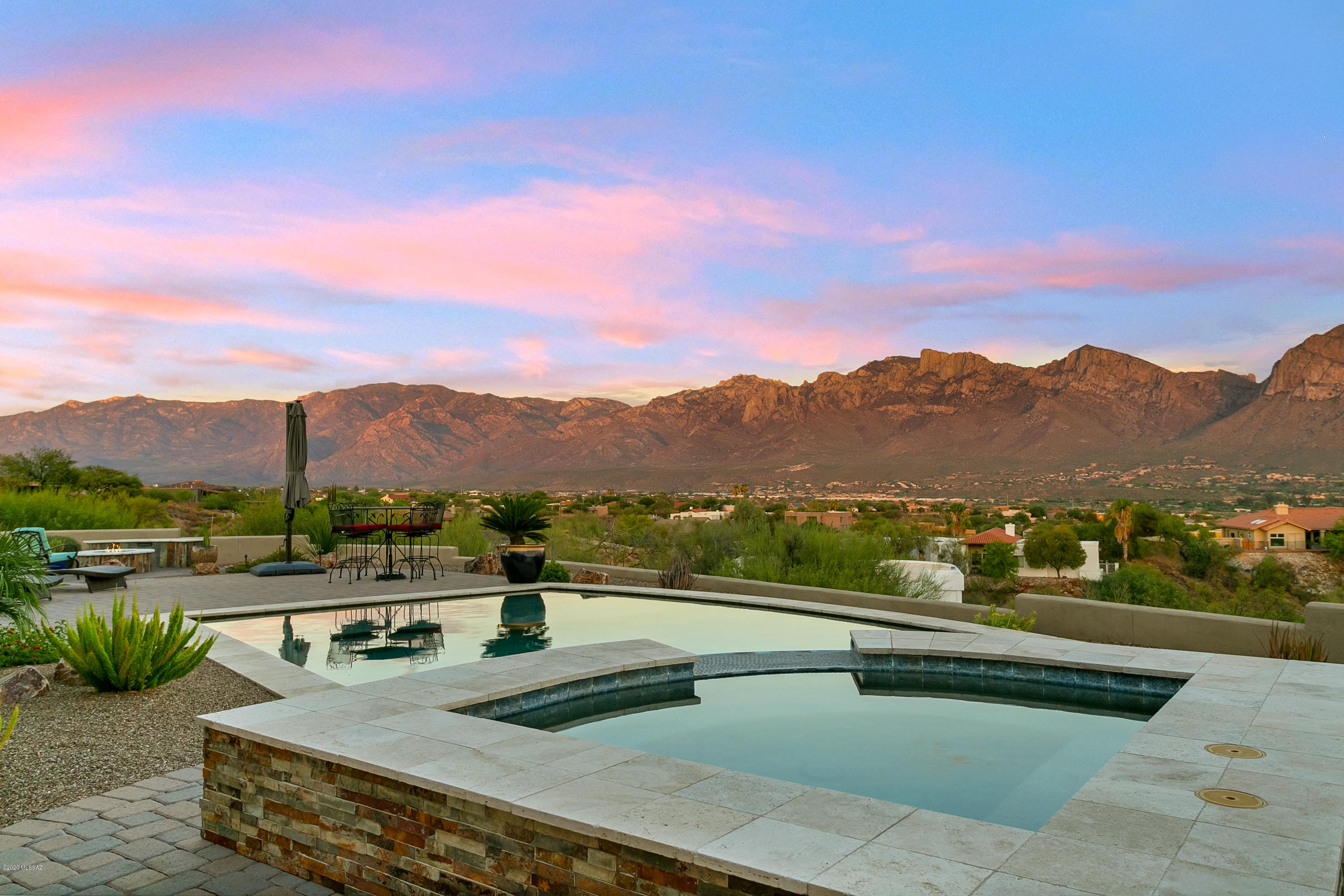Once in a lifetime opportunity awaits you! This home is positioned high on a elevated lot showcasing unsurpassed 360 degree views.  From the  1100 square foot patio perfectly designed to showcase the Catalina Mountains and twinkling city lights at night, you have multiple areas in which to enjoy this thoughtfully designed backyard. The Pool & Spa are only the beginning as you have a built in BBQ grilling area and Fireplace under the covered patio in addition to a gas fire pit 
with blue glass out in the open air portion of the yard.
Should you get tired of watching the panoramic Catalinas head to the front courtyard and watch the sunset over the Tortolita Mountain Range.
The kitchen is designed for the Discriminating Cook & The 1200 Sq Ft Garage for the Hobbyist ! This  home has it all