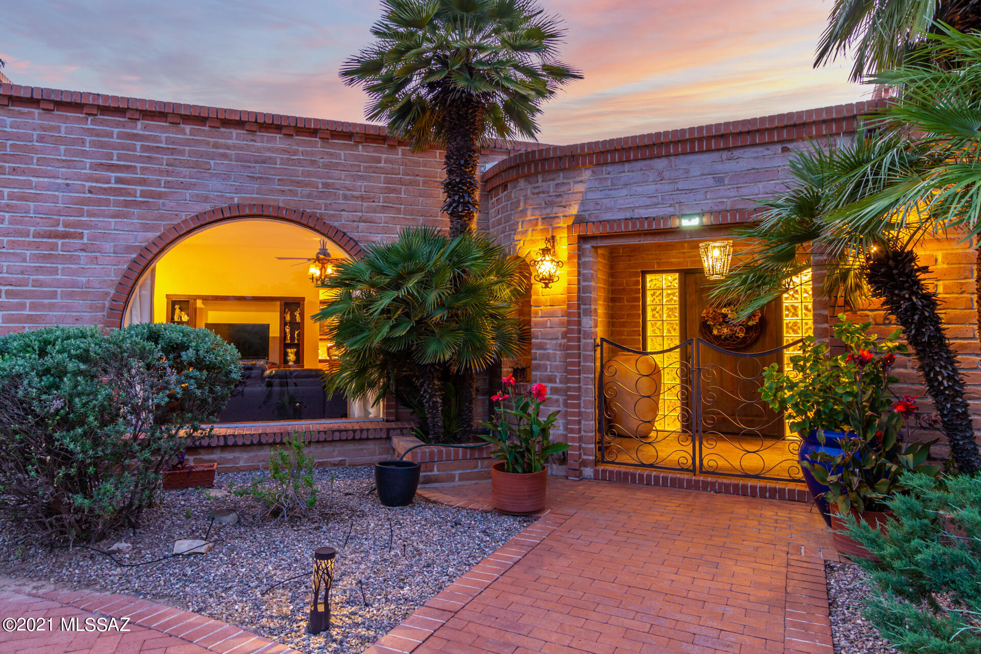 Classic Tucson Country Club burnt adobe situated on a .54-acre lot in the coveted Tucson Country Club Estates. Welcoming courtyard entry and a bricked circular drive lead to architecturally pleasing details within this Territorial home. Inviting foyer overlooks an expansive backyard complete with green grass, mature trees, and an inviting covered patio with Adobe arched accents. Entertaining will be a delight with so many spaces to gather and enjoy. Interior features attractive an extensive Mexican tile flooring, French doors, Talavera tiled bathrooms, a warm natural palette, and ample natural light. Spacious living room is accented with both an impressive southwestern Adobe gas fireplace, and a large arched picture window. Open kitchen features a commercial style six burner range with a stainless-steel hood vent, beautiful Talavera tile counters, nook and picture window overlooking lush backyard. The community boast fantastic family-friendly opportunities, like picnics and parades to block parties and strolling. Come see what you are missing! This section of the community is not a part of the homeowners' association.