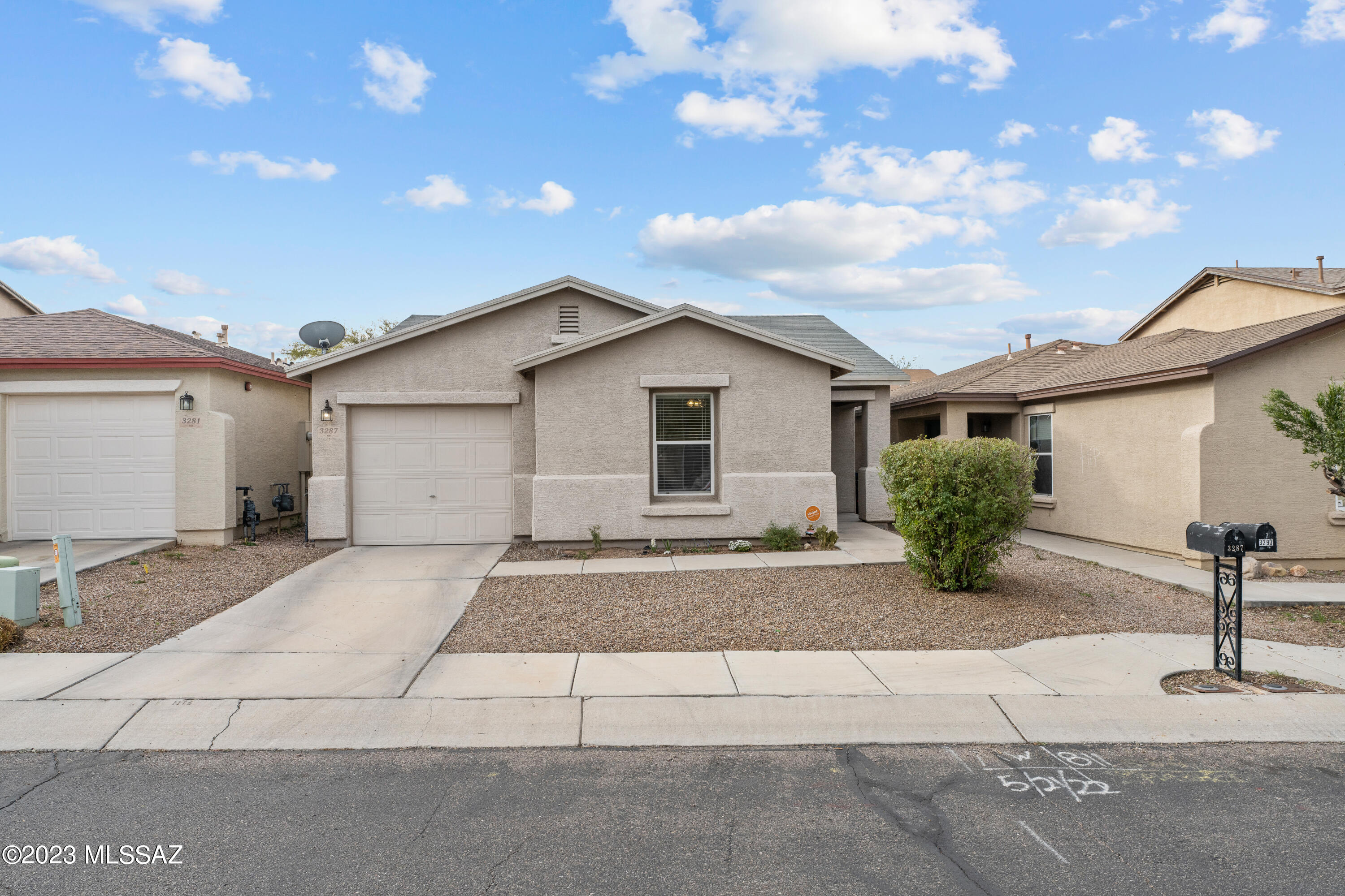 Cute as a button, move in ready home in the Northwest Tierra Del Paraiso neighborhood. The adorable two-bedroom home boasts numerous updates since 2020 including wood look laminate floors throughout, new baseboards, lighting & plumbing fixtures. White kitchen with breakfast bar, newer stainless appliances including a gas range & side by side refrigerator. Bath with free-standing vanity with raised bowl sink. Round decorative mirror & floating shelf convey. Laundry closet with 2020 Samsung washer & dryer. Relax on the covered patio with ceiling fan &  enjoy the cute backyard with raised beds perfect for planting herbs & flowers. Fenced yard for pets. Security system. 2020 HVAC. Roof replaced 2023. One-year home warranty included. Why rent? Make this your home sweet home today!