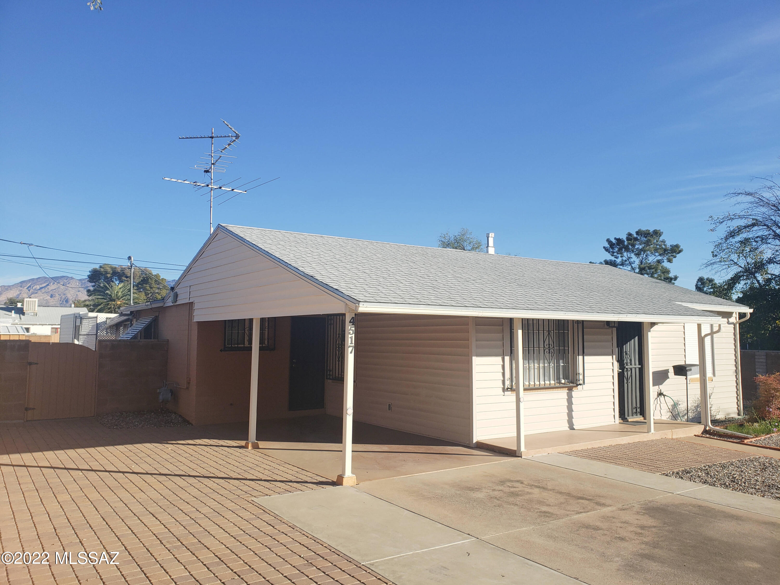 Close to the UofA, Banner Hospital, Park Place & El Con Malls, this mid century brick home is a great starter or investment in very desirable Poets Corner. This Retro 3 bedroom home has updated utilities featuring central AC, dual heating, 2 full baths, family room with built-in entertainment center, ceiling fans, huge Arizona room and a bonus workshop. Large pool sized property is fenced and gated with a 11x15 ramada and storage sheds, carport, covered porch and paved parking for a motorhome. Property is big enough to qualify for a guest house! This home has curb appeal and a clean look with newer roof, siding and front yard pavers. Numerous upgrades and features throughout the house. Enjoy as-is or remodel ready. Floor plan available. This find won't last! Dryer does not convey!
