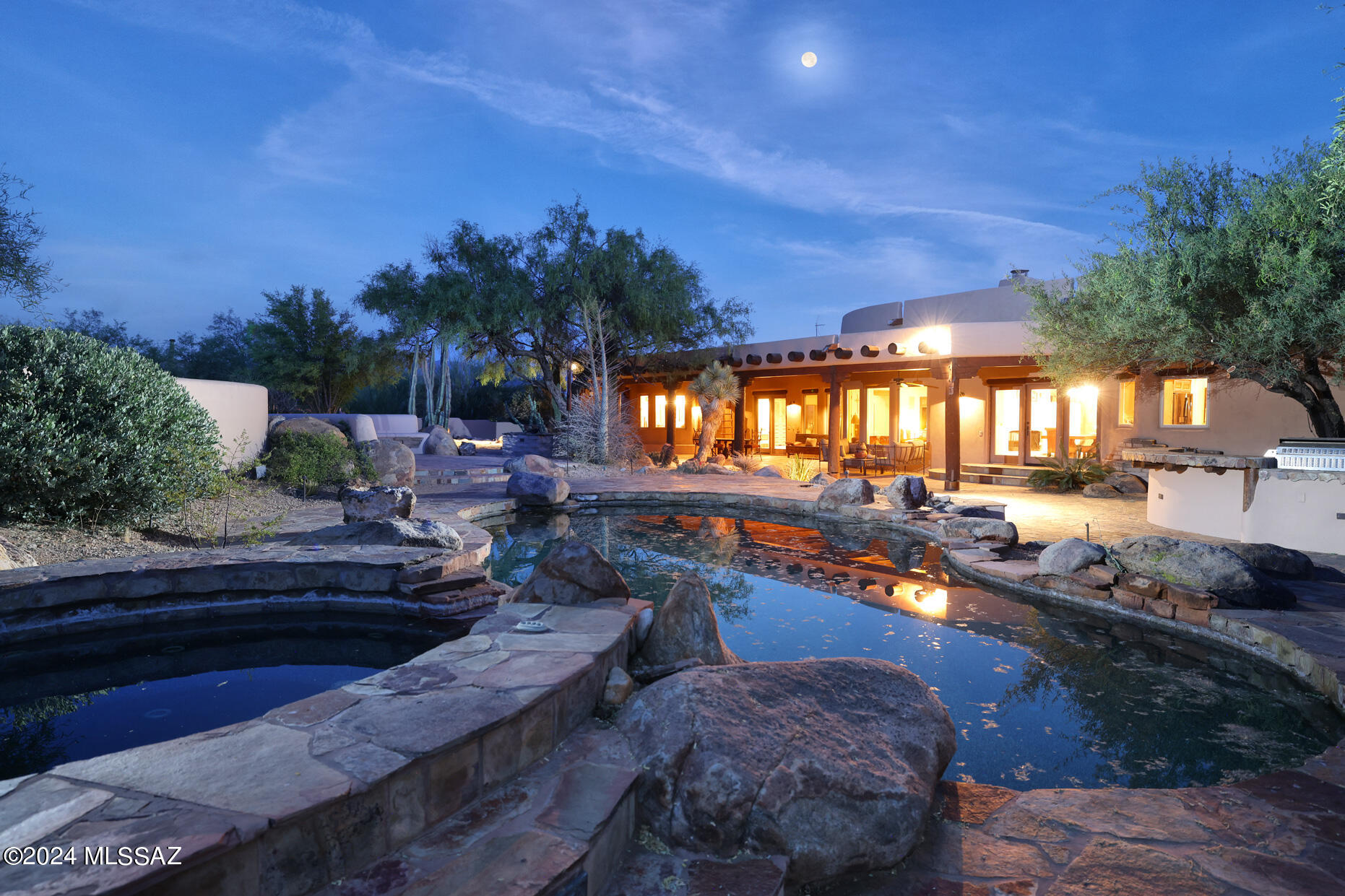 This custom Ray Birch home is located on over 3 acres in a gated community of only 9 homes.  Sitting at the base of the mountains and Catalina Highway just South of the National Forrest boundary, the surrounding desert offers a secluded and tranquil environment.   This home features a 3 coat stucco finish, hand plastered walls with integrated color, unique ceiling treatments , niches, kivas, coved ceilings and saguaro rib vent covers.  Primary Suite has a spacious bath, fireplace, and adjacent den.   Numerous courtyards & patios surround the home and provide access to beautiful landscaping, a tranquil water feature, specimen cactus, pool, spa, bbq area, fountain, and gorgeous mountain views.  Guest bedroom has an ensuite bath and walk-in closet.  Green house offers multiple uses.