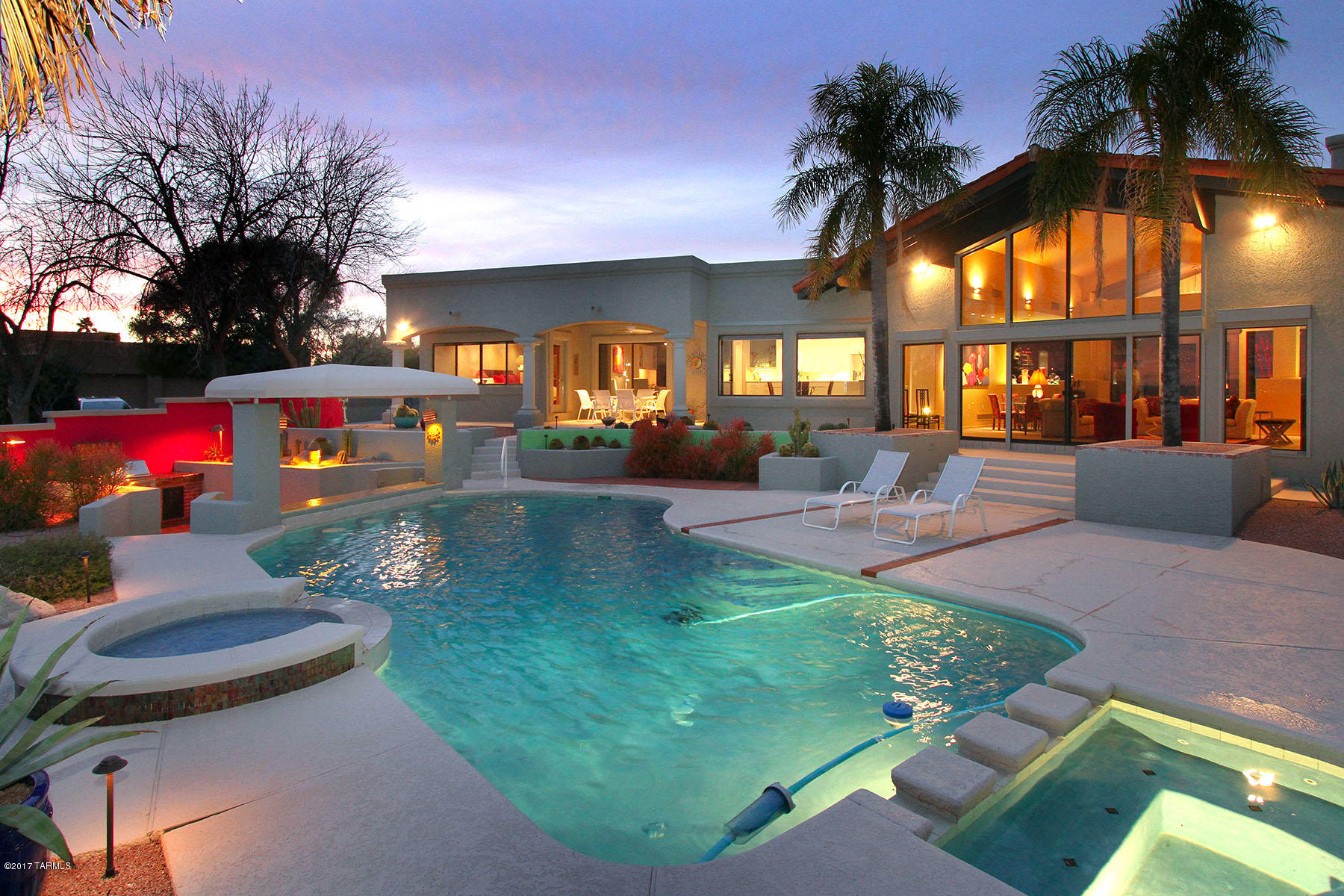 Perched high above the city in coveted gated Cobblestone you will find your contemporary vision of paradise. This home expertly choreographed from entering the foyer leading to sunken living room showcasing expansive city views...truly the best Tucson has to offer. Amenities abound from luxurious formal living room w/built-in bar and soaring high ceilings to sophisticated master bedroom suite w/fireplace, private patio & recently updated award-winning master bath. Finely appointed kitchen w/adjoining family room leads to covered patio overlooking resort-style glistening pool/spa with swim-up bar w/4 bar stools and built-in BBQ for seamless indoor/outdoor entertaining. This glamorous, contemporary home is desert living at it's best!