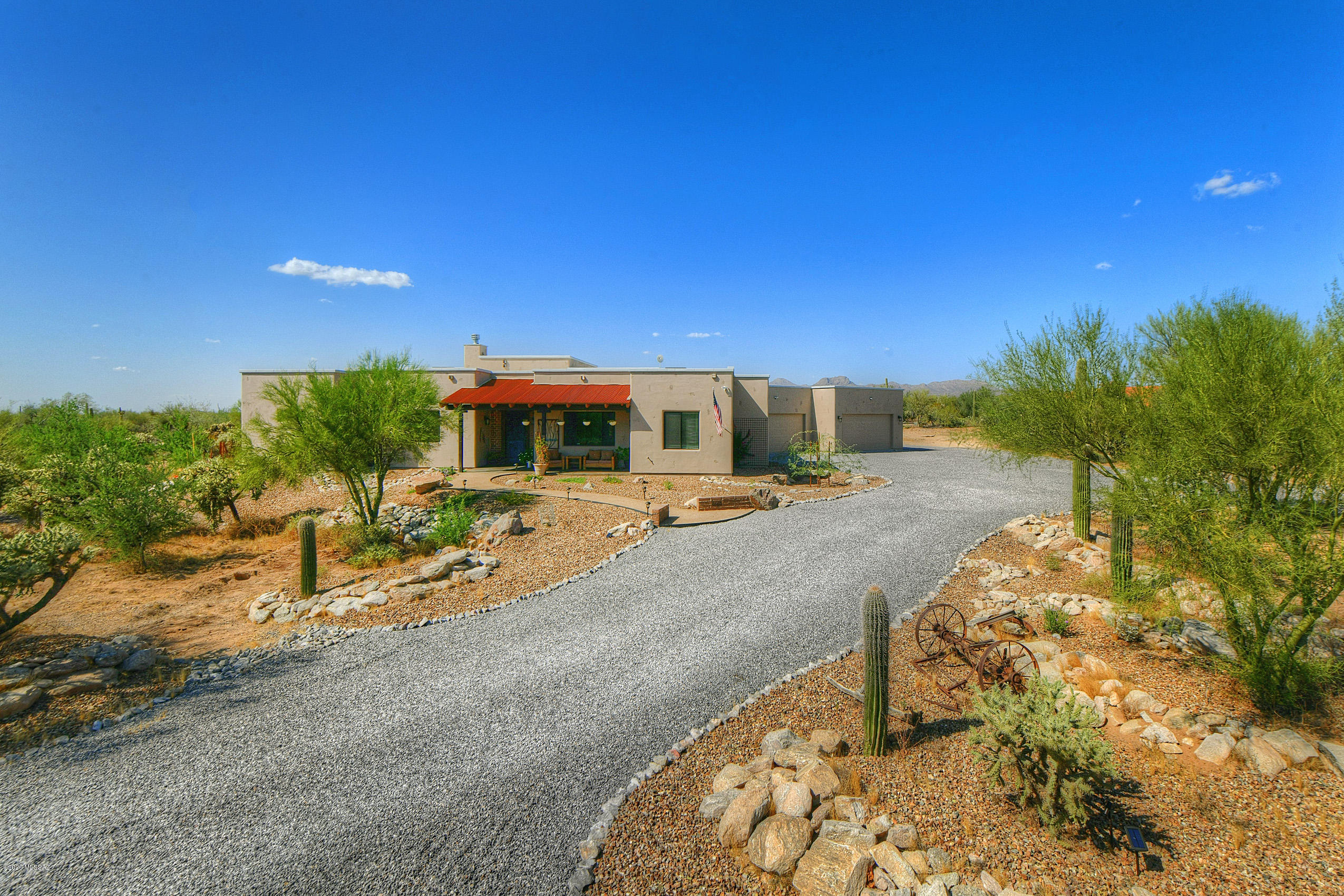 Custom Tucson Ranch Style Home situated on a desirable lot just under 2 acres! Enjoy blue skies, starry nights with breathtaking views! This 4 bedrooms, 4 bathroom split floorplan with vaulted ceilings, polished concrete floors, views from living room with a cozy fireplace, Extra Wide Hallways and Doorways throughout. The Gourmet Kitchen features Stainless Steel appliances, Custom Cabinets, granite and Steel counter tops. Relax or Entertain under the large covered patio that offers Peace, Serenity, and great views. Fenced back yard fully landscaped with irrigation and synthetic grass. Front & Backyard w/water harvesting landscape design in. Large 1296 Sqft 4 car Extended Length, Over Height Garage. Paved road. Conveniently Located Close to Restaurants, Shopping, and Schools. No HOA.
