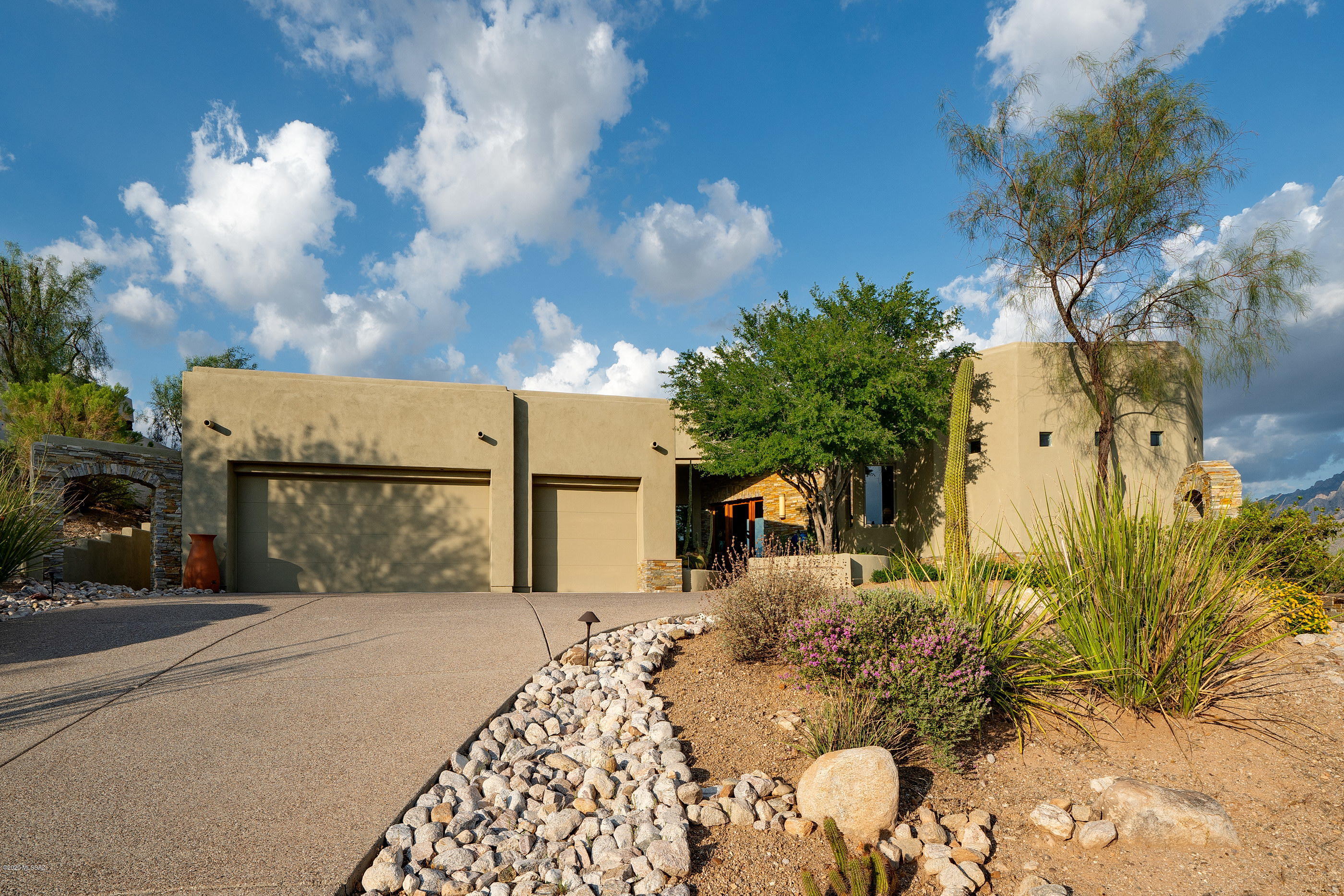 Enjoy some of the most dramatic Catalina mountain and expansive valley views from this privately situated hilltop residence. Offering an open and bright split bedroom plan, featuring 3,190 square feet, with three bedrooms + den, three bathrooms and interior spaces that range from open and soaring, to cozy and intimate. Interiors take full advantage of natural light, blurring the boundaries between the interior and exterior spaces. Soft rounded corners with walls of glass allow interior spaces to expand outward encompassing the sweeping view corridors framing the full range of Pusch Ridge and the Catalina Mountains. 

Upon entry, you are greeted by a large Great Room acting as the central hall, establishing the main connection point of the home. The natural travertine stone floors, juxtaposed against the Mannington hardwood, float seamlessly throughout the space, providing a subtle contrast to the warm tones and textures. 

The heart of the home is the fabulous Chef's kitchen with gorgeous finishes throughout, including solid custom cabinetry, complemented by granite countertops, sleek chrome door pulls and top-end stainless steel appliances, surrounding the exquisite custom-tailored breakfast bar featuring an array of service counter space, acting as a focal point in this kitchen of range and proportion. The breakfast dinette opens onto a spacious family/living room, designed to substantial scale and comfort.

Sequestered on the North end of the residence is the oversized master suite, complete with a patio walkout and luxurious master bath with dual vanities, walk-in shower and an oversized closet. Two secondary en-suites are featured on the South end of the home, privately situated and perfect for family, or guests alike.

Enveloping the residence are numerous outdoor living spaces that seem to stretch out over the valley below, each having been thoughtfully positioned to procure seamless indoor-outdoor entertaining while out on the sun-drenched terrace, offering al fresco dining, overlooking the resort-like pool and spa, both elegantly and effortlessly nestled within space.

This home is an embodiment of the Tucson Lifestyle!