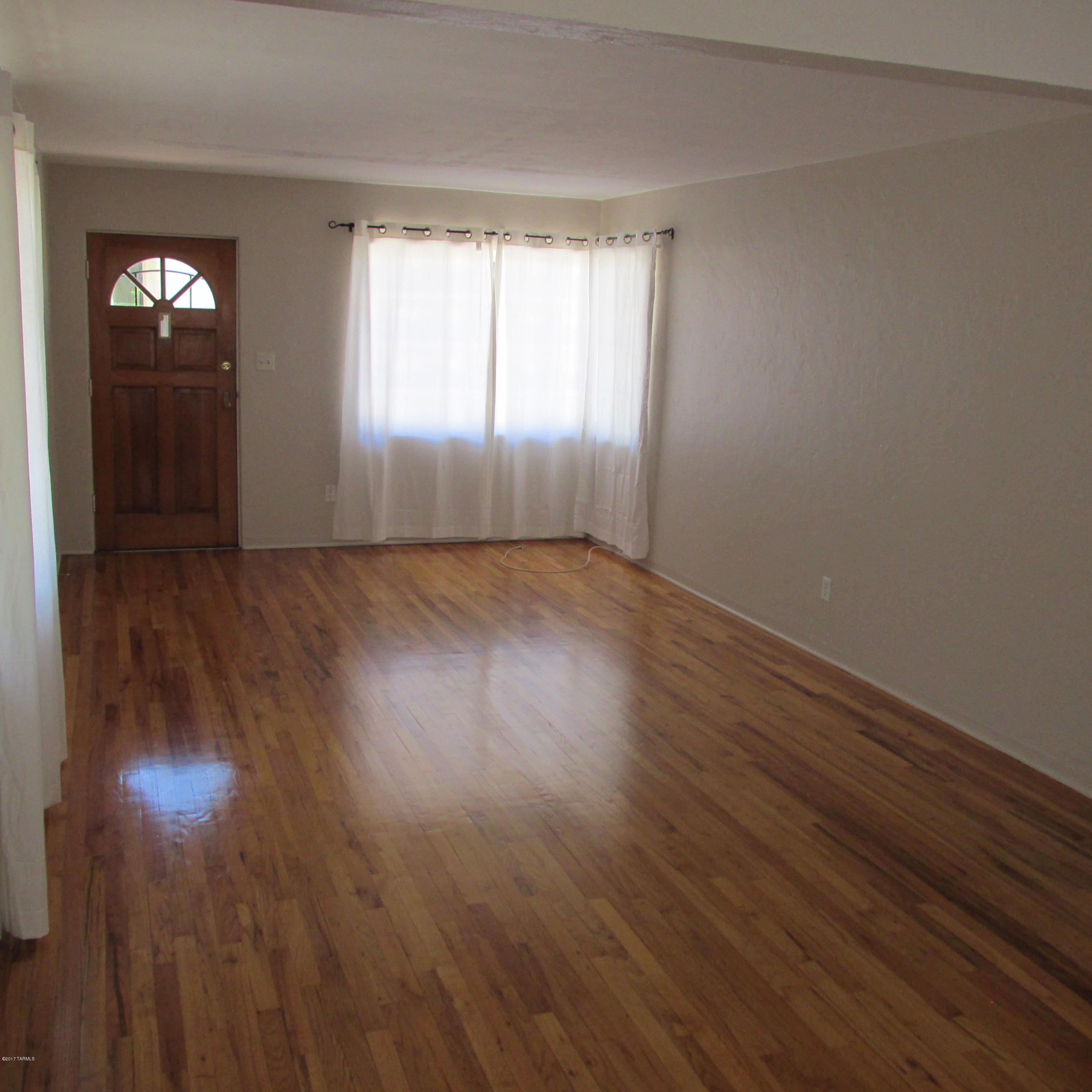 Sam Hughes 1057 sq. ft. vintage home with hardwood floors throughout is in great neighborhood just 2 short blocks to the university. Updated kitchen with newer appliances: gas stove, microwave, dishwasher & refrigerator. This duplex's laundry room has a washer & dryer with pantry storage. Newly refurbished tile bathroom & spacious bedrooms with walk-in closet. Separate dining room & living room looks out on the landscaped back yard. Private & fenced backyard with motion lighting & landscaped with Palo Verde & Mesquite trees for shade. Off street covered parking, and access to a storage room in a separate building at the back of the property that's perfect for your bikes and BBQ. Rent includes water, garbage, & gardener. New dual pane windows to be installed to help with energy efficiency