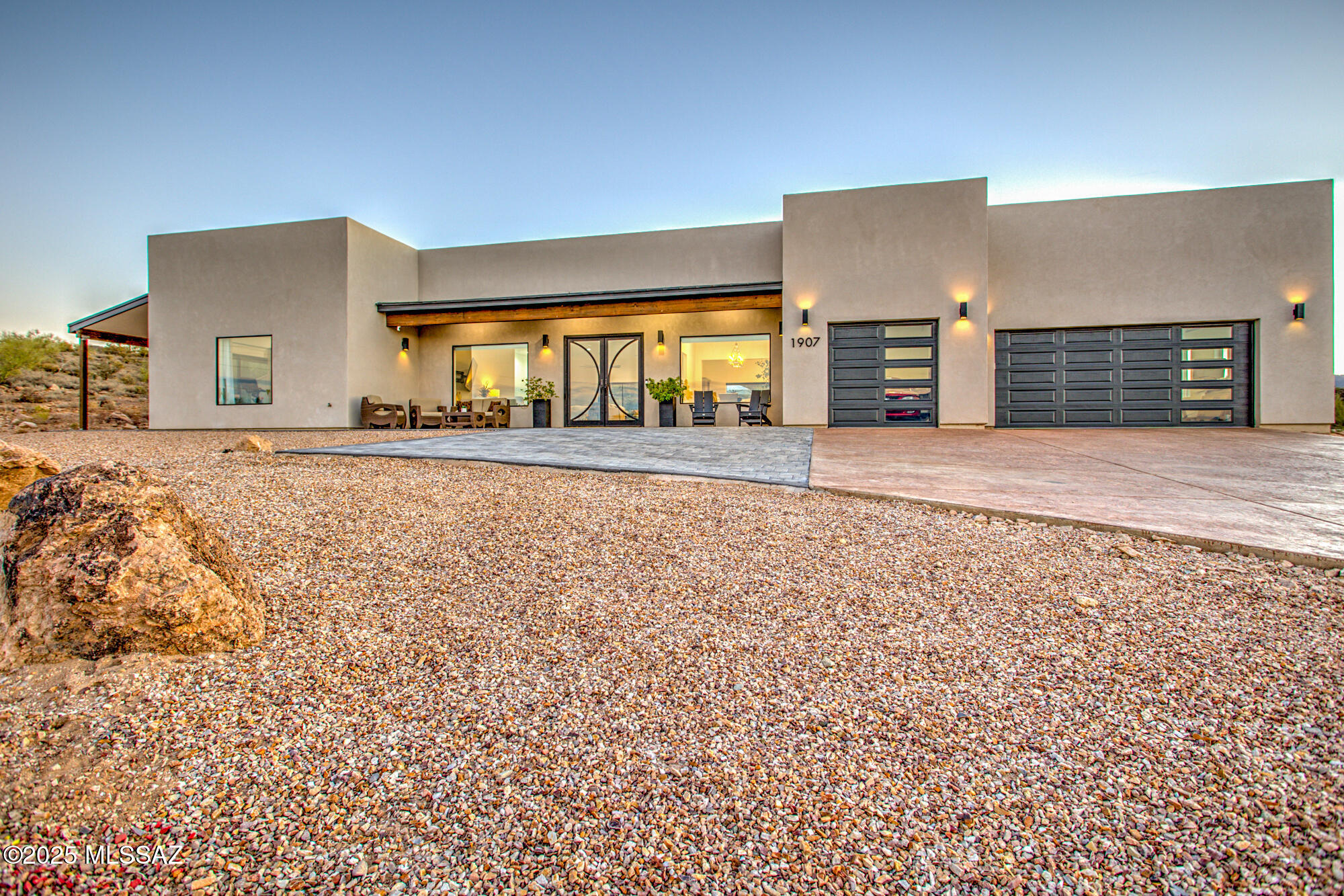 Modern Elegance at the Top of the Hill. Experience elevated living in this stunning contemporary retreat, perfectly perched to capture breathtaking 360-degree views, among the best in Tucson. Designed for those who appreciate modern luxury, this home features sleek architecture, soaring 12-foot ceilings, expansive view windows, and designer-selected finishes throughout. The open-concept Great Room effortlessly accommodates multiple seating areas and flexible dining options, ideal for entertaining on any scale. The chef's kitchen is a standout, featuring a professional-grade appliance suite, a generous walk-in pantry, and an oversized quartz island that invites gathering. Quartz countertops continue throughout the home, enhancing its seamless elegance. The primary suite offers a private sanctuary complete with a customized walk-in closet and a spa-inspired bath. Of the 3 additional bedrooms, one includes its own ensuite, providing comfort and privacy for family or guests.
Enjoy resort-style living with a backyard designed for relaxation and entertainment: a sparkling pool and spa, covered patio with extended paver seating and dining area, turf lawn, and multiple additional patios-including a full length covered patio, all set against a backdrop of unparalleled majestic city, desert and mountain views. Additional highlights include a 3-car expanded garage, spacious laundry room with pet wash station, a wet bar with wine and beverage coolers, gas fireplace, water softener, and exceptional privacy throughout the outdoor spaces.
This is not just a home...it's a lifestyle defined by design, comfort, and panoramic natural beauty.
Excellent location for commuting at 11 minutes to Banner Hospital and University of Arizona, 20 minutes to TMC, 7 minutes to Downtown Tucson, 20 minutes to Raytheon and 5 minutes to I-10 Access.
No HOA.