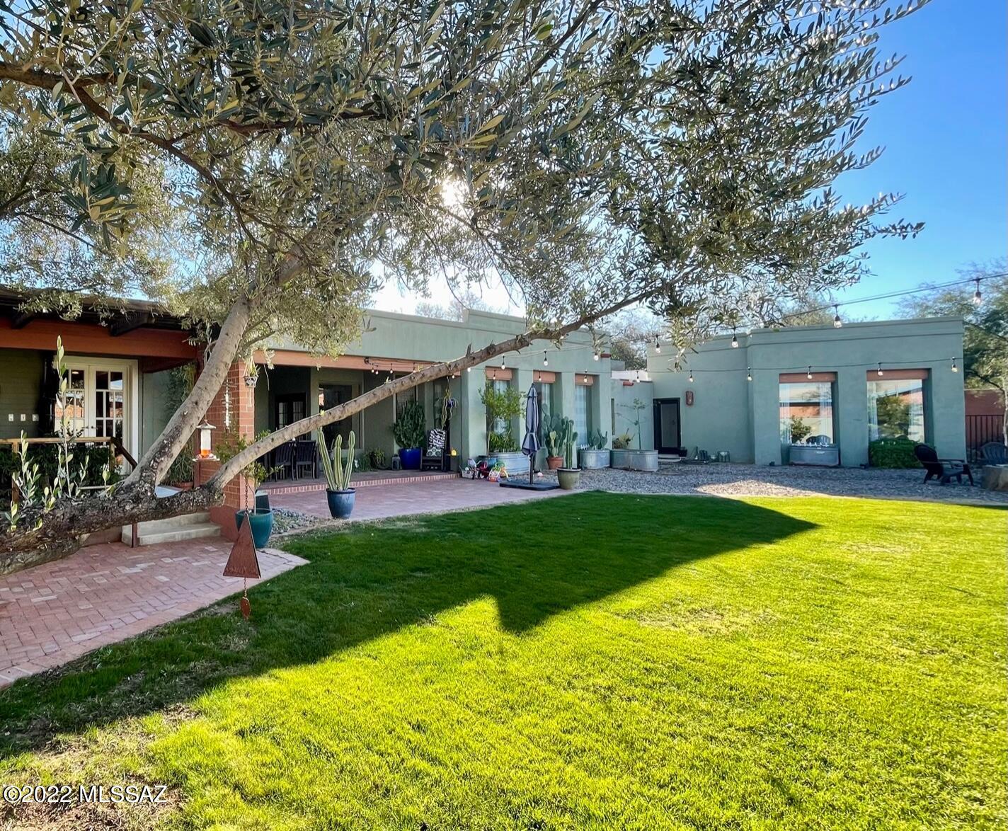 This sprawling home in Historic Catalina Vista strikes a lovely balance between vintage details and modern amenities. Enter through the living room and dining room to a wall of windows in the large media/family room which opens to the outstanding back yard. Custom metalwork, citrus trees, and two porches make this a true oasis. Inside a split plan offers 3 bedrooms and two bathrooms plus a primary suite with walk in closet, stunning en suite bathroom, and adjacent den/office with beamed ceilings. Minutes to the Arizona Inn, Banner Hospital, and the University of Arizona.