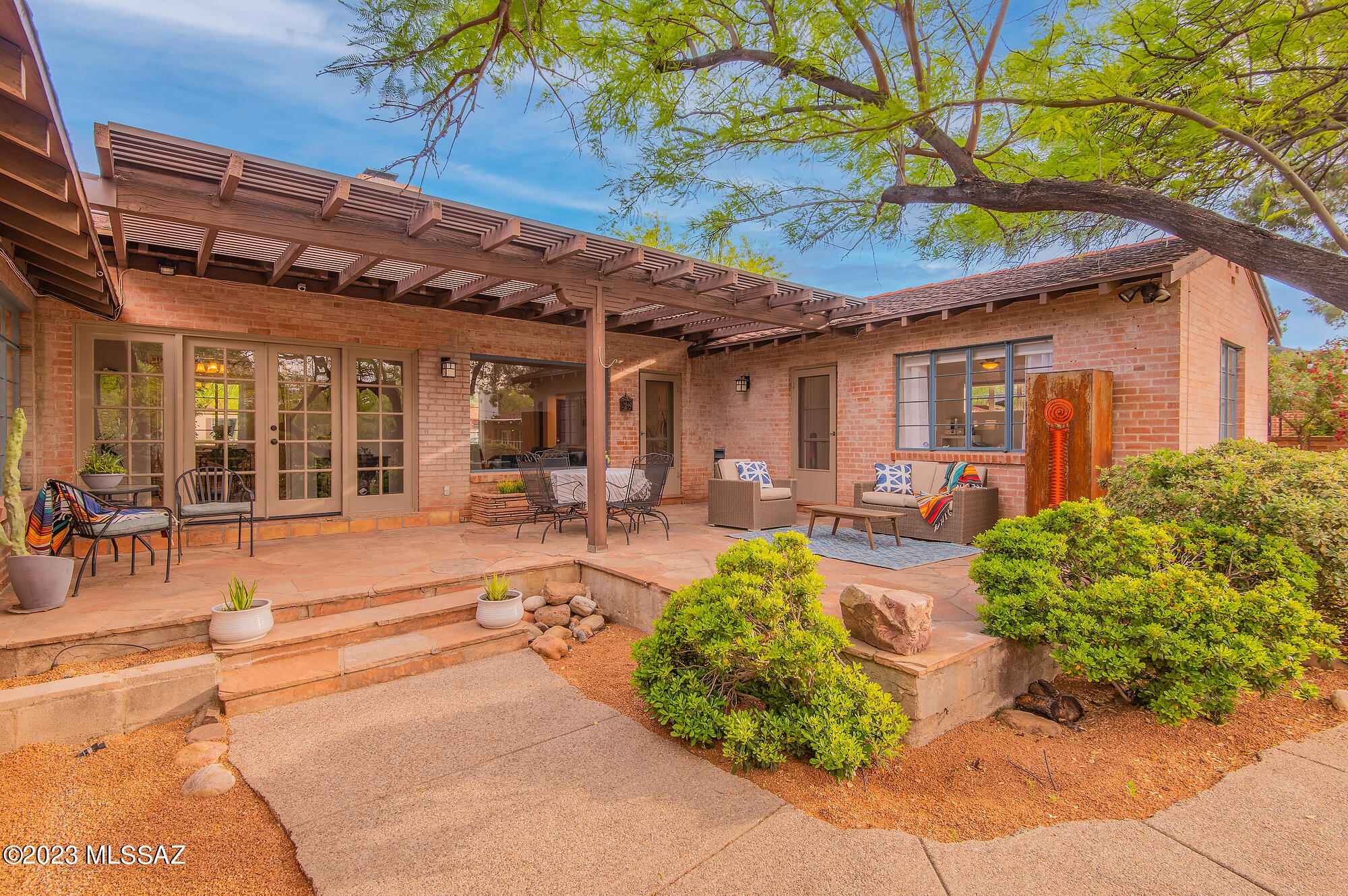 This sprawling brick home and guest house in Historic Catalina Vista are just minutes to Banner UMC hospital and the University of Arizona. Under a canopy of mature trees the manicured grounds, pool, and numerous outdoor spaces create an unparalleled oasis right in the middle of town. Inside, hardwood floors and charming details couple with bright picture windows and high ceilings. The enormous kitchen has island seating, gourmet gas range, and granite countertops. Three bedrooms and three bathrooms in the main house are situated in a split floor plan for added privacy. Utilize the guest house for visitors or as a pool casita for entertaining. Two car garage, additional storage, and copious closets make this home uncommonly practical. Just a short walk to Tahoe Park, Restaurants, and the famous Arizona Inn.