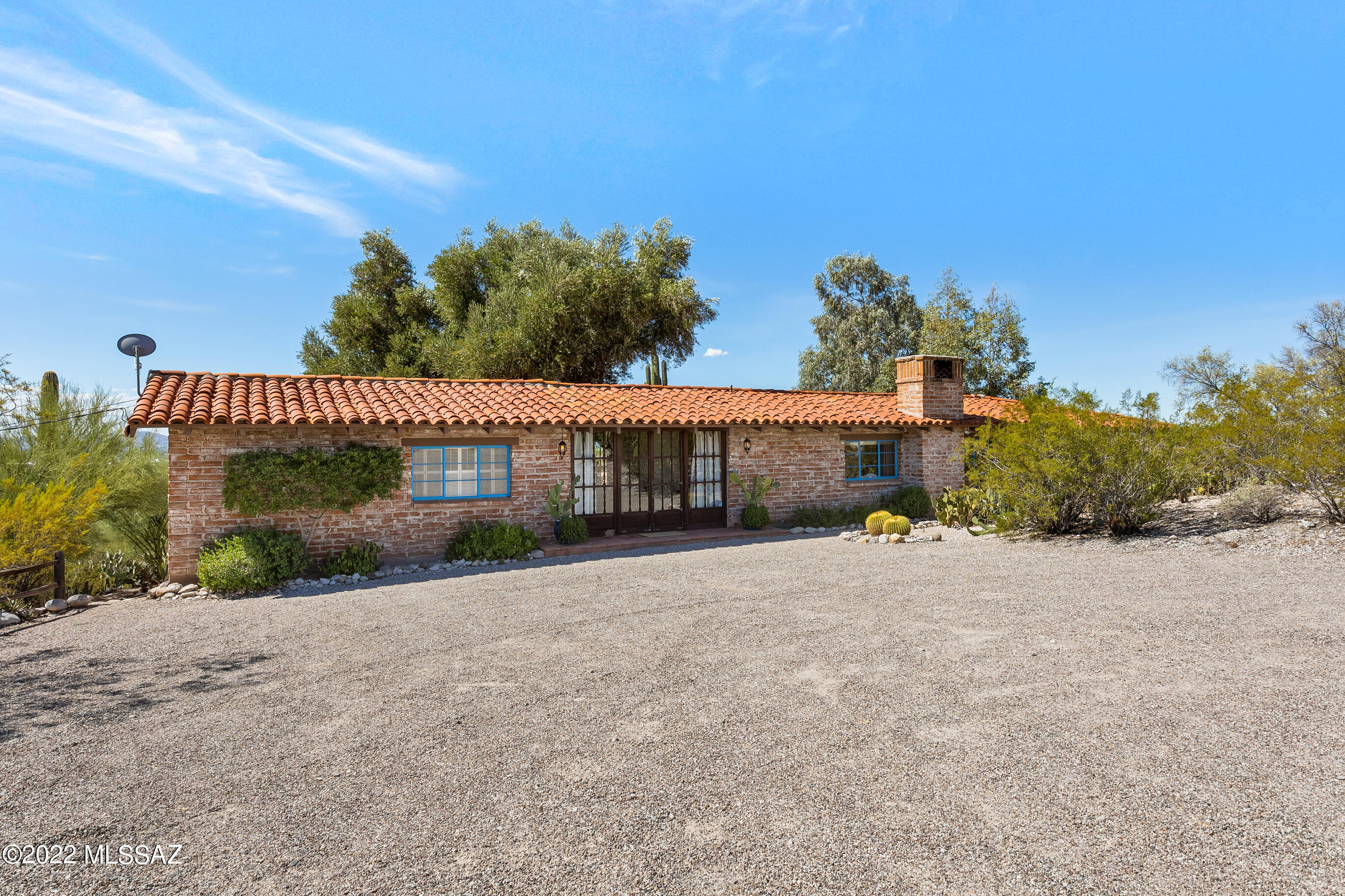 Charming Hilltop Joesler retreat with views of the mountains and Tucson Valley on 3.38 acres. Built in 1954 the home retains its original charm, hardware, and woodwork.  The main home features wood floors with gorgeous custom French doors leading to the patios.  Enjoy the light filled living room with vaulted ceiling, wood burning fireplace & hidden closets with great storage. The Guest House has a bedroom suite and living area with hookups in place to add a small kitchen, plus its own covered patio with beautiful views.  The wraparound covered porch overlooks the green grass, sparkling pool, and Tucson Valley. Design, orientation, and finishes make this architecturally interesting home a fine example of a Joesler.  Amazing potential for the right buyer to keep or expand on the the original home while potentially splitting off another two lots.  Follow the path past the citrus trees to the west of the pool to discover your own Rock Labyrinth and more amazing views of the Tucson Valley.