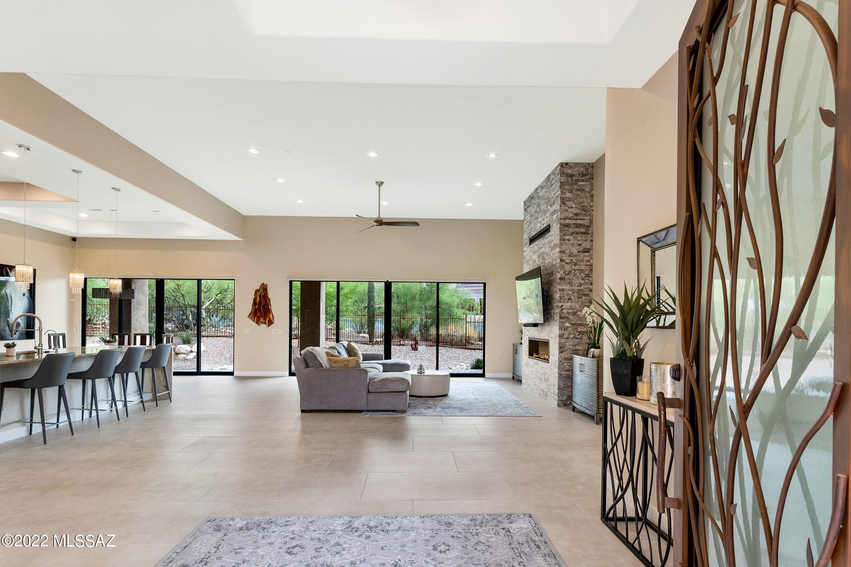 Beautifully and recently built home by top quality custom builder Sanctuary Construction is now available!  A rare find in the elite gated community of LaPaloma Ridge Estates completed twenty months ago and visited by Midwest owners. 
The exquisite metal garage door and patterned paver driveway plus free flowing walk welcome you to your modern desert home. 
Once entering through the custom front gate and designer door, you walk into the open floor plan with soaring 13 foot ceiling that effortlessly lend an airy feeling through the home. 
This 4 bedroom and 2.5 bathroom residence features a huge kitchen area and great room, classy oversized porcelain tiles, large pantry, nice dry bar and uniques details making this an entertainment masterpiece. Serene mountain views including the famous Finger Rock mountain can be seen from the many windows and comfortable backyard.  Hot tub is set in attractive rock and slab stairs with wrought iron decorative privacy screen.  After your hot tub experience, rinse off in your outdoor shower area and sit back and enjoy beautiful desert landscaping under the fully covered patio with fans above.  
No detail overlooked in this remarkable palace!