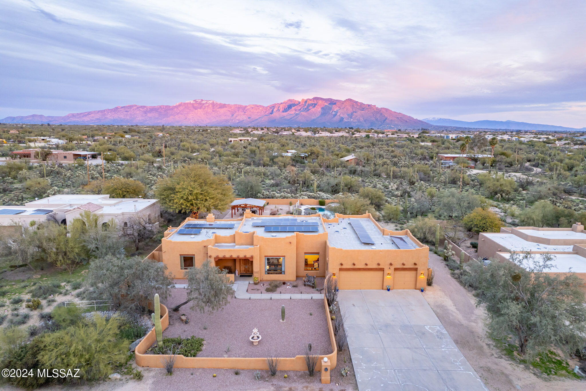 Tucked away in a quiet neighborhood on a dead-end street, 9938 N Sunset Creek Place offers residents a desert oasis close to conveniences.  Situated on nearly an acre lot with plentiful open space behind, this property showcases unobstructed mountain views and excellent privacy. Santa Fe style architecture blends beautifully with the natural surroundings, creating a comfortable and relaxed experience. Upon entry, views of the Catalina Mountains are prominent, with beautiful desert vegetation in the foreground. A functional single-story layout spanning 3,032 sq ft includes 4 bedrooms (2 on either side of the home), 3 full baths and 2 living spaces. Timeless, but subtle Southwestern design elements dotted throughout the home include beamed wood-clad ceilings, Saltillo tile, beehive gas fireplaces, and Talavera tile. Soaring ceilings and large windows throughout the residence create an open, airy feeling. Built-in speakers are found both indoors and outdoors. The robust owned solar system keeps the home cool, while maintaining minimal utility bills.

Outdoors, the Tucson lifestyle is front and center, ready to accommodate gatherings of any size. Fully enclosed with a masonry fence, the backyard includes multiple zones with Eastern exposure providing afternoon & evening shade. The heated pool and spa are fenced separately for safety. An outdoor cooking area with a built-in BBQ, refrigerator and pizza oven is situated off from the kitchen for great function and flow. Recently added in 2022-2023, a large area of synthetic grass and separate putting green leads way to a huge custom solid wood ramada with electrical.

The extended 3-car garage provides excellent storage for vehicles, tools and toys and includes a utility sink. Should additional storage be required, the lot offers ample space to add an RV garage, storage sheds or other additions.

Lifestyle and convenience from this location are plentiful. Within a half mile there is a plaza with a coffee shop & retail, the Crooked Tree Golf Course, a park with playground, soccer fields and more, a small winery, horse stables, and the Maeveen Behan Desert Sanctuary Trail System with 4.7 miles of trails. Access to Interstate-10 is quick, making commuting, traveling Downtown or to the Phoenix metro area simple.