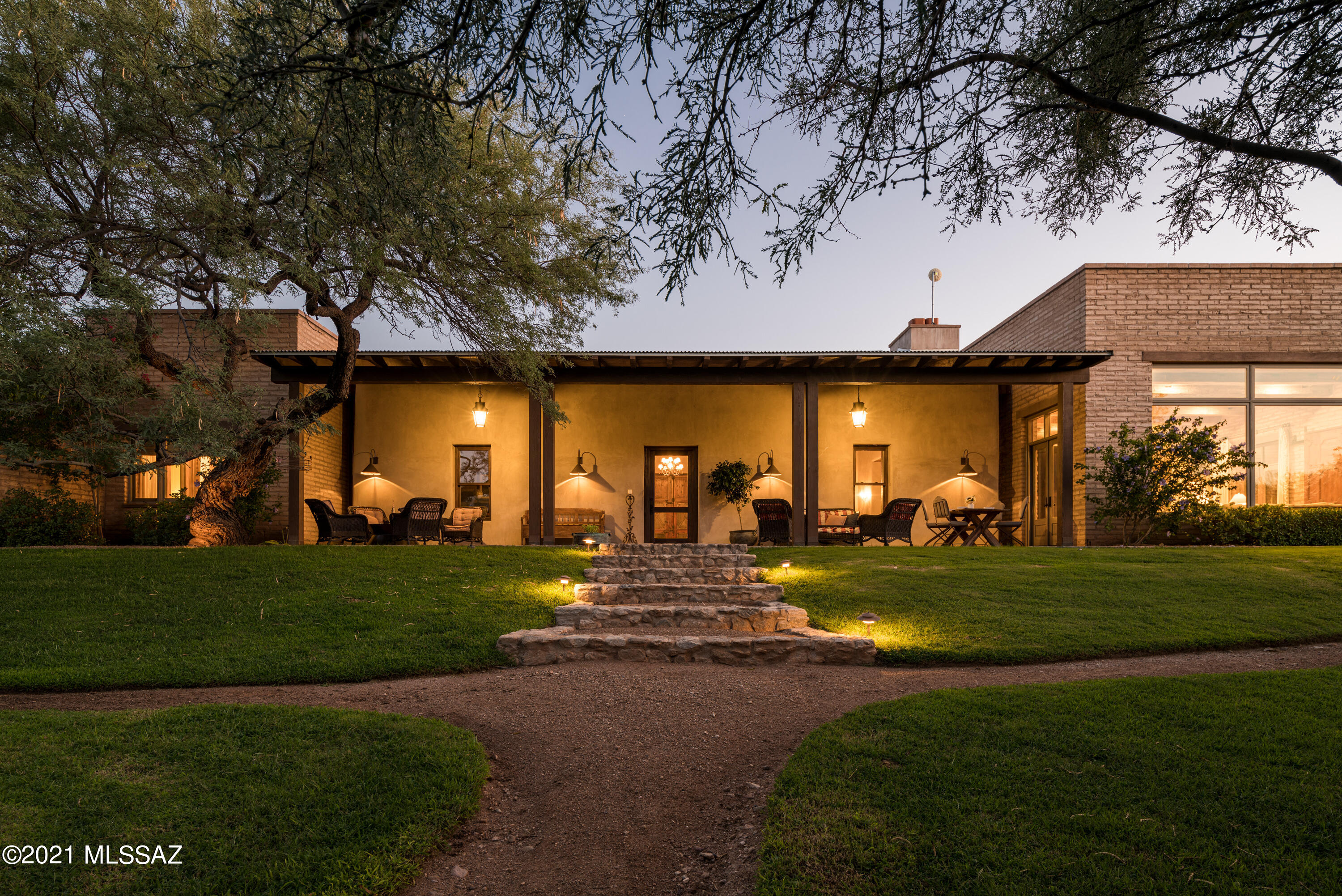 Situated on a secluded 20-acre private estate, nestled within the surrounding mesquite bosque of the Tanque Verde Creek, with landscapes that unfold beyond the monumental antique French iron entry gates leading to an expansive motor court that circumnavigates much of the estate. This experience results in a backdrop that draws the eye out to the impeccably curated and tailored grounds. Featured on the cover of Phoenix Home & Garden, with interiors that feature a collection of clean, but variously textured walls, a visual study of its environment, where color, shape, light and shadow seduce the endless combinations of this stunning vernacular home... The tradition-infused mud adobe materials, juxtaposed against naturally aged patina, creates warm and inviting spaces that engage the human spirit in an atmosphere of peace, well-being and freedom. 

Sited on an ideal North/South axis and beyond the home's traditional Territorial reveal, one is greeted with soothing tones and textures, complimented by the exquisite attention to detail of this designer home, providing a visual and tactile experience. The massive oak antique wood front doors open onto a significant historic structure dating back to the 1800's, serving as the core of the home, allowing the living spaces to flow easily, yet offers a sense of privacy and separateness. The historic part of the house, a former stagecoach stop, leads to a sophisticated living room, with reclaimed pine floors and reclaimed barnwood beamed ceilings from Montana. The rooms flow seamlessly, with simplicity of form and expressive spatial compositions creating wonderfully functional spaces. 

Designed with lofty ceilings and proportions, the great room provides vast volume of scale and space, while also retaining a welcoming sense of intimacy. The kitchen's disciplined design features reclaimed Chicago brick floors and antique barnwood beamed ceilings, set off by stainless steel professional series appliances. The island, which incorporates a native mesquite butcher block at one end, is topped off and juxtaposed against the soft gray Caesarstone countertops. Centrally located, the kitchen has two dining areas and a reclaimed brick pizza oven, and opens on to the great room, with the lush grounds stretching out beyond the North facing windows.

A sumptuous owner's suite is privately sequestered on the East wing of the residence and is ideal for those who want single level living. A series of exterior doors open onto the grounds and covered verandas, filling the room with soft natural light, providing a reintroduction to the home's effortless blend of laissez-faire. The spa-inspired bath, with a walk-in steam shower, and soaking tub ensure a luxurious user experience, and opens to a private enclosed garden with fountain and outdoor shower.

The site was specifically designed to preserve a generous portion of exterior space, allocated for outdoor living, with the home opening onto a series of large, covered verandas on each side of the property, serving as an extension to the interior living spaces. Designed for the quintessential Arizona lifestyle, a full outdoor kitchen and separate 621 square foot guest house, with rooftop viewing deck look out over the verdant gardens and meandering landscapes, conceived for year-round entertaining. The estate has mature fruit orchard with apples, plum, pear, peach, apricot and pomegranate and elevated gardens made from Catalina stone, all enclosed by a beautiful hand-crafted mesquite ranch fence perimeter.

Whether you're a novice, champion, or simply a spectator, the equestrian facilities will draw you in with a fully equipped and built-out tack room, offering saddle, rein and riding equipment storage, half-bath, in addition to four horse stalls, a wash station, riding arena and access to trail riding for all levels with trails on the property and trails directly accessible from the side yard. Farm fresh eggs can be selected from the large chicken coop situated next to the horse paddocks.  A new 25,000 gallon water storage tank, along with 3 wells (2 Active and 1 Permitted), run through a sophisticated water purification and advanced water filtration that supplies water throughout the residence, guest house and facilities (City of Tucson water is also available on property). 

This ultra-private retreat offers both cutting-edge design, breathtaking views, and a timeless pedigree, situated within moments of the Tanque Verde corridor, offering acclaimed dining, shopping and entertainment. The property has been meticulously updated and maintained, with all new top of the line mechanical equipment.  The estate offers proximity to hundreds of miles of hiking, cycling, and horseback riding from Tanque Verde Creek and trails to nearby Saguaro National Park. This is one of the finest examples of an Arizona Estate Property and a true oasis in the Sonoran Desert.