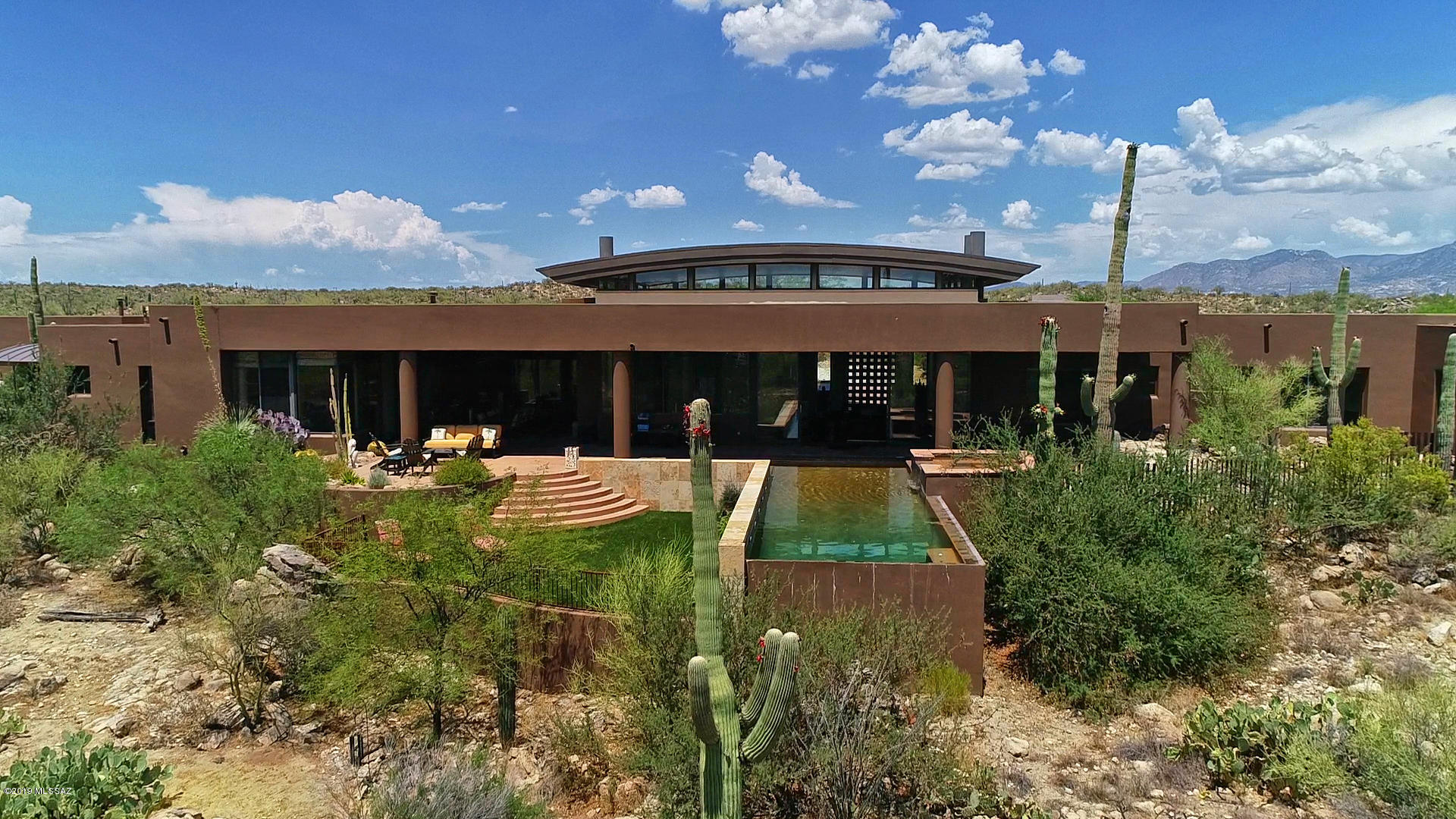 Custom contemporary masterpiece designed by Ron Robinette in exclusive guard-gated Honeybee Ridge overlooking Honeybee Canyon with unobstructed views of Pusch Ridge, the Tortolita Mountains and Tucson city lights. The views, privacy and serenity of this home's setting will never be compromised. This home's setting and serenity are equaled by the architectural perfection of its interior: Open Floor Plan, Vaulted Tongue-in-Groove Wood Ceilings, Window-Walls to frame the views, Scored Polished Concrete Floors and Deep Covered Patios all incased in Solid Masonry Walls. The spa-like master suite features a soaking tub surrounded by windows that capture the beauty of the Sonoran desert. All guest bedrooms are en suite and the open floor plan makes this home ideal for hosting parities and overnight guests. Entertaining inside or out is enhanced by two architecturally significant fireplaces. Uncompromised design, incomparable views, serene setting and privacy...this home has it all!