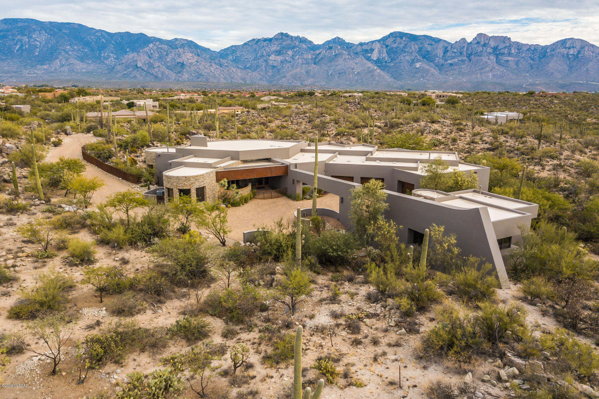 Seller will accept all offers between $1,999,000-$2,199,000.  Privacy and Seclusion at its finest, no expenses spared, gorgeous solid masonry construction bordering common area with Saguaro Studded Mountain Views.  Ron Robinette designed home featuring real quartz veneer and caps, Belgard paver driveway, lighted bridge to guest house, wrought iron and glass double entry doors, 24'' travertine flooring, commercial grade Thermador stainless appliances, granite counters, island w/prep sink, gas stove w/pot filler, Hubbardton Forge lighting, Crestron Control Systems Smart Home, Whole House Entertainment System, solid wood Alder Doors, custom cabinetry, each bedroom has its own bath, home office, solid masonry construction, (click on more) $300k in Custom window treatments and automatic shades/blinds, heated saltwater pool and spa with natural rock waterfall.  Separate 1 Bedroom, 1 bath Guest House with kitchenette, living room, dining area and cozy fireplace.  Gorgeous views and privacy abound.  See attached Features List and Floor Plan.  You NEED to see this home.