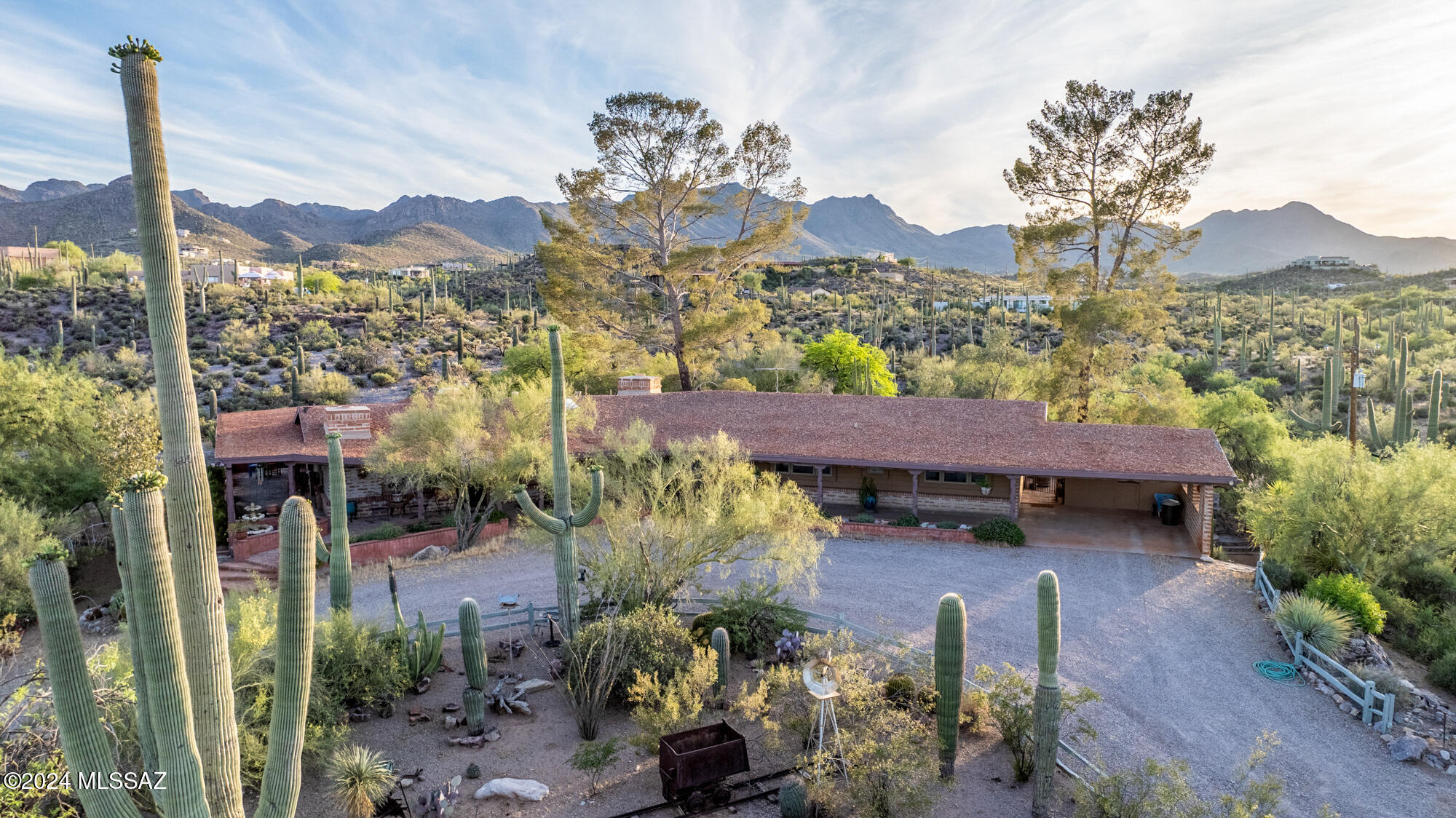 Introducing a timeless retreat—an authentic Old Ranch House crafted from beautiful, original adobe, nestled on over 10 acres of pristine land. This expansive property offers unparalleled privacy and a true Western charm, perfect for those seeking a connection to the past with the conveniences of today.

Step inside and be captivated by the craftsmanship: solid wood sourced locally and featured throughout, with stunning wood-beamed ceilings and rustic paneling in between. The home exudes warmth and character, ideal for someone who appreciates an old western aesthetic. The cozy fireplace in the living room invites you to gather and relax. Outside, the landscape is graced by towering saguaros and mature desert vegetation, offering multiple serene sitting areas to take in the breathtaking