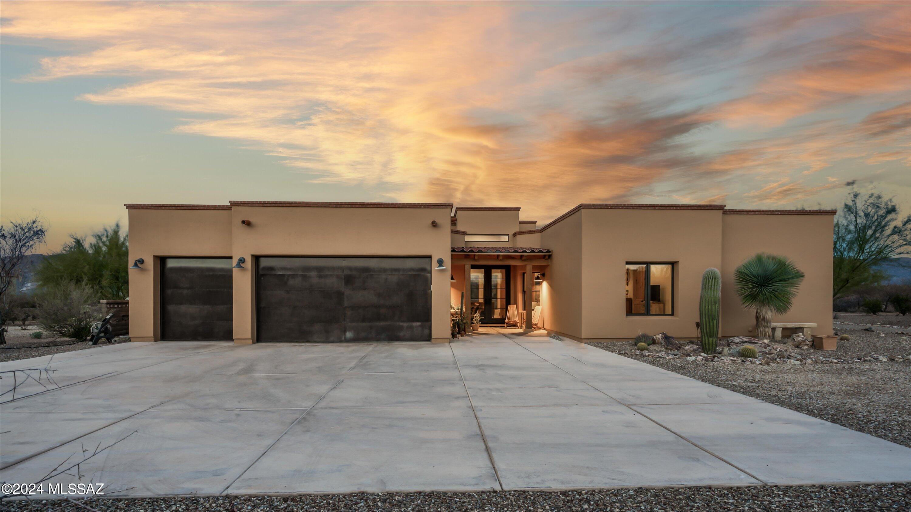 Welcome to your oasis of elegance and comfort, where every detail has been carefully curated to enhance your living experience. Situated on 1.29 acres with breathtaking views of the Rincon Peak, This property is a testament to luxury living in the desert. Enter through custom doors designed by San Juan Iron Works. Tongue and groove ceilings in the great room which extend to the outside back patio. Concrete floors throughout. The gourmet kitchen features high quality appliances, ample counter space and a sophisticated cooking space. The primary suite  is filled with rustic charm and modern elegance which features a cozy fireplace, one wall has a striking display of stacked stone and the expansive windows  frames the stunning views of the Rincon Mountain range.  Enjoy entertaining in the backyard retreat, complete with solar heated sports pool surrounded by lush artificial turf which offers low-maintenance and is visually appealing year round.  Truly a show stopper!