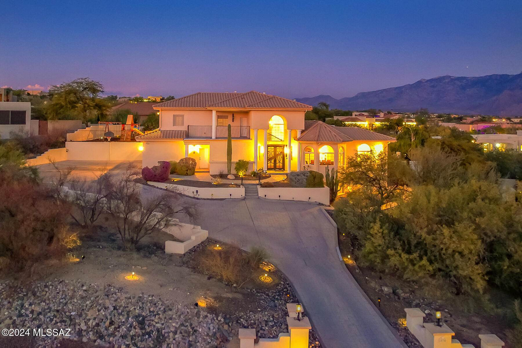 ABSOLUTELY BREATHTAKING custom 6BD/4.5BA (5,140 sq ft) multi-level estate within gated Canada Hills Estates boasts picturesque mountain, sunset and city light views plus dual primary suites, den, media/game room and fabulous outdoor oasis. Dramatic foyer with soaring ceilings and wrought iron staircase flanks a formal dining room with elegant bay window and a living room. Beyond lies an impressive gathering room highlighted by stacked stone media wall with ledge fireplace plus 2-story stone columns. Striking gourmet kitchen hosts large center island with beverage fridge, quartz countertops and SS appliances including dual ovens and gas cooktop. Main level hosts large primary or guest suite with luxury bath, sitting room, huge walk-in closet and French doors off rear patio. Upper level with front balcony hosts second primary suite with luxury bath and private balcony plus 2 additional bedrooms, den and hall bath. Plenty of additional space for family and guests on the lower level encompassing a large media/game room, 2 bedrooms plus hall bath. Neutral tones throughout plus large picture windows, gorgeous plank flooring, stacked stone wall accents, upper level skylights, granite countertops in baths, plus wrought iron railings and front entry door. Large bonus room could be butler's pantry plus laundry & powder rooms. Retreat outdoors to enjoy the covered & uncovered patios with Catalina views, dual grill stations, triple-feature gas firepit plus large heated pool with new rock waterfall and retractable cover. Expansive decorative turf lawn flows to a fenced play area. This amazing home is steel framed and exterior was repainted with warranted Rhino Shield coating in 2023. A truly spectacular desert retreat for the most discerning buyer!