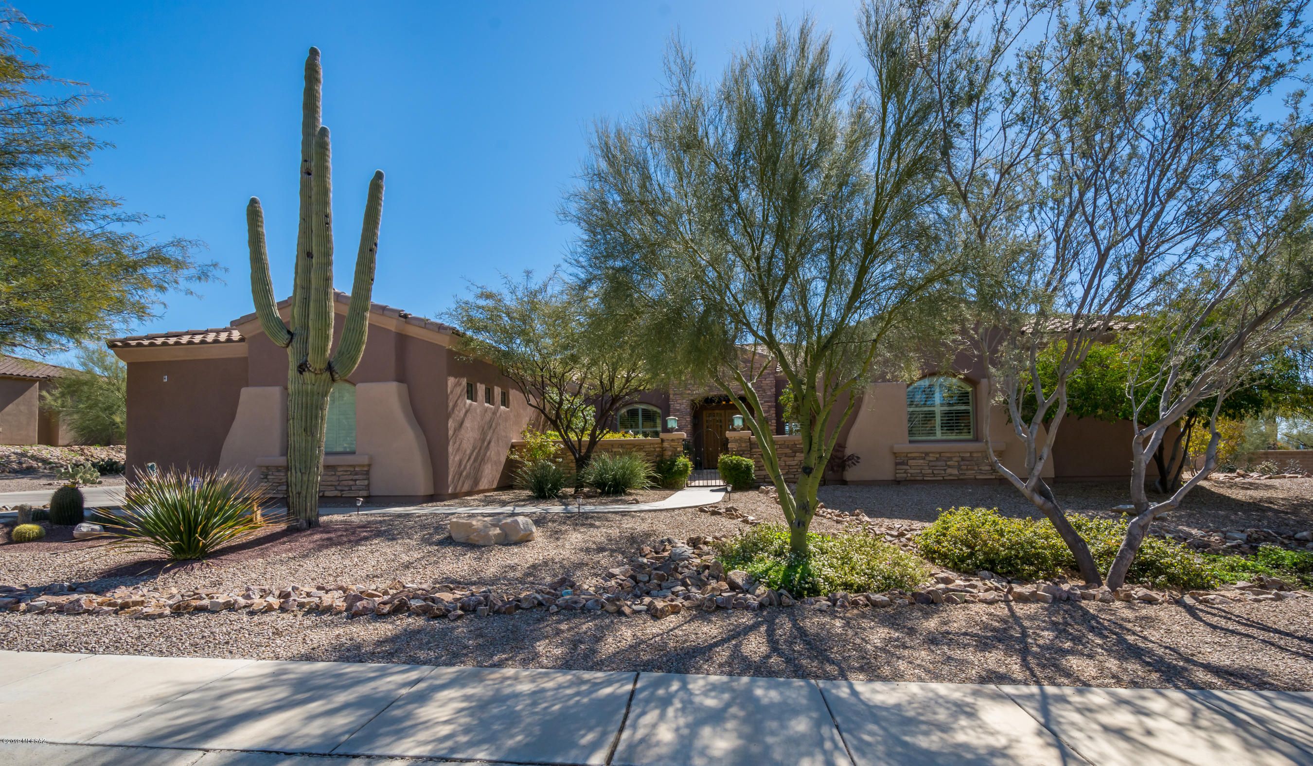 Soft contemporary, professionally decorated & located near the 3rd green of Gallery South Course w/Sombrero Peak Views on over 1/2 acre. Gated courtyard w/fountain. Open greatroom w/Stacked stone FRPL, spacious office & formal dining nearby. Kitchen boasts ''reedglass''Black lacquered cab. w/full bksplash, enlarged island w/5 burner gas cooktop, custom SS Vent-a-hood, GE Monogram, DBL ovens, refer, wine fridg. Split plan w/master, dual sinks, soak tub, walk-in shower & 2 large closets. 1 BD/1BA on same side. Other side of home offers powder rm, 2 BD/2BA w/addt'l living QTRS. Extended patio w/beach entrance pebbletec pool, spa, waterfall, gas FRPL, built-in BBQ, putting green. mature trees. Travertine/Shutters/fans/custom paint thru-out, laundry rm w/sink. Cen vac, 3 car gar, w/storage cab.
