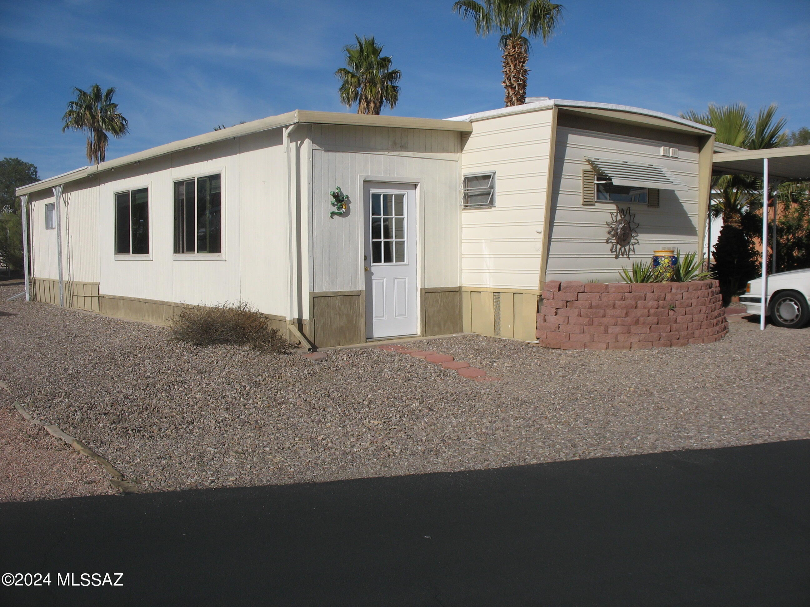 Very nice and clean furnished and updated home with large added on area on west side of the home. This home appears small by square footage standards but added on area adds 400+ SF to home. Main home has laminate flooring. AZ room has ceramic tile flooring. Roof coated January 2024. Master bath has tub and shower and ceramic flooring. Added on side has a half bath an second bedroom. Workshop/shed behind carport. The HOA fee in this 55+ community includes unlimited golf, tennis, pickle ball, shuffleboard, pools, spa, exercise room, trash collection, and much more. You own the land!