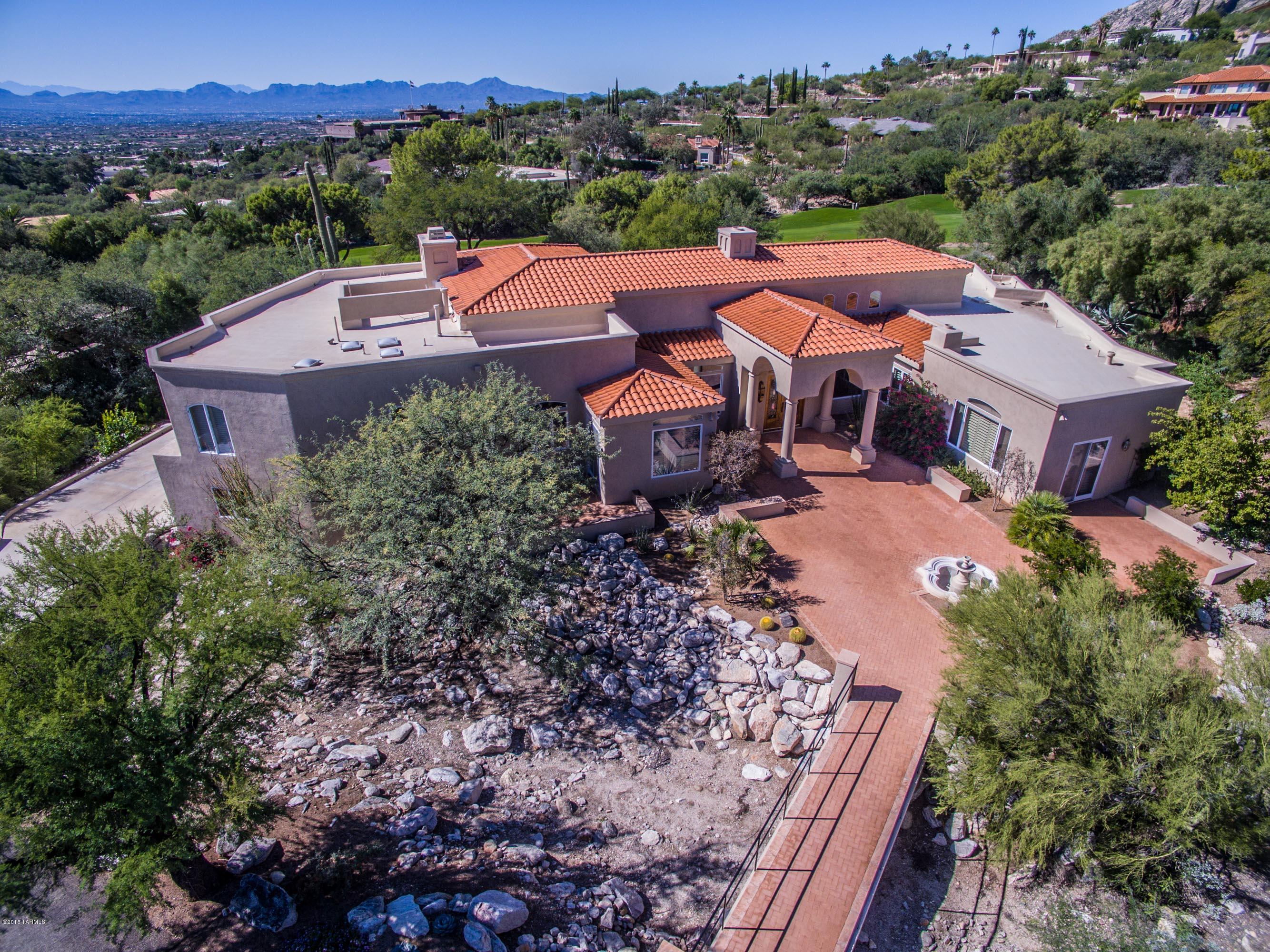 Serene and elegant Mediterranean with absolutely stunning city and mountain views overlooking the 11th fairway in prestigious Skyline CC Estates. You will be in awe over the lovely bridge over a wash leading from the circular drive to the beautifully landscaped yard w/fountain, the custom leaded glass/carved wood entry door, formal foyer with soaring ceilings & dramatic dual sided stone fireplace. Numerous french doors, crown molding, hardwood floors and custom shutters throughout. Gourmet kitchen w/ custom cab's, granite, built-in frig, wine cooler & wine rack. Master suite w/ FP, dual vanities,Jacuzzi tub, marble tile, & huge walk-in closet. Beautiful resort style custom built pool/spa, covered patio, brick pavers, Island w/gas grill, prof. landscaped w/low care desert foliage and cacti.
