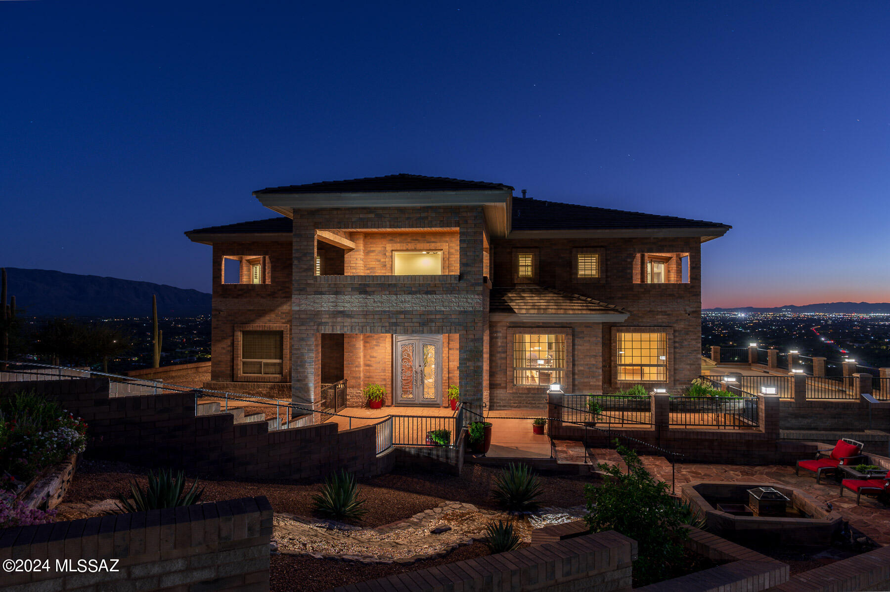 Private property, showings are by appointment only, please do not walk the property w/out an appointment as the home is occupied.  
Welcome to your dream home! Spectacular luxury hillside estate that embodies elegance and sophistication.  The stunning property offers breathtaking panoramic views of the valley, city, and majestic mountains-perfectly framed by floor-to-ceiling windows that invite natural light and showcase the captivating landscape, creating an enchanting atmosphere for both relaxation and entertaining.  As you step through the designer Iron double front door, you are greeted by a grand foyer that sets the tone for the exceptional residence.  An elegant staircase leads to the second story, where every detail has been meticulously crafted. The expansive main living area features a formal living room with a striking stone fireplace, a refined den, a stylish powder room, and a generous family room-each space thoughtfully designed to harmonize comfort and luxury.  Culinary enthusiasts will be inspired by the gourmet kitchen, boasting exquisite, chiseled granite counters, premier Jenn Air stainless steel appliances, a sophisticated wine fridge, and an impressive island with a gas cooktop and seating area, perfect for having lavish gatherings.  Indulge in the opulence of the master suite, complete with a cozy fireplace and private balcony access for breathtaking views.  The master bathroom is a sanctuary in itself, featuring a jetted tub, an expansive walk-in closet, a double vanity adorned with chiseled granite and a luxurious glass-enclosed walk-in shower with an elegant stone accent wall.  Each guest room is designed for ultimate comfort, featuring its own full bathroom and private balcony entrance, ensuring an exclusive retreat for every visitor.  Entertainment options abound with a stylish game room located on the garage level, while multiple outdoor living spaces invite you to embrace the beauty of the desert landscape.  Enjoy vibrant wildlife and the mesmerizing city lights at night as you unwind in these serene settings.  The front patio, featuring breathtaking mountain views and a tranquil waterfall feature, enhances the allure of this extraordinary home.  Experience Vida Ladera- "hillside Life" living at its most luxurious.  Don't miss your chance to claim this unparalleled hillside sanctuary as your own!