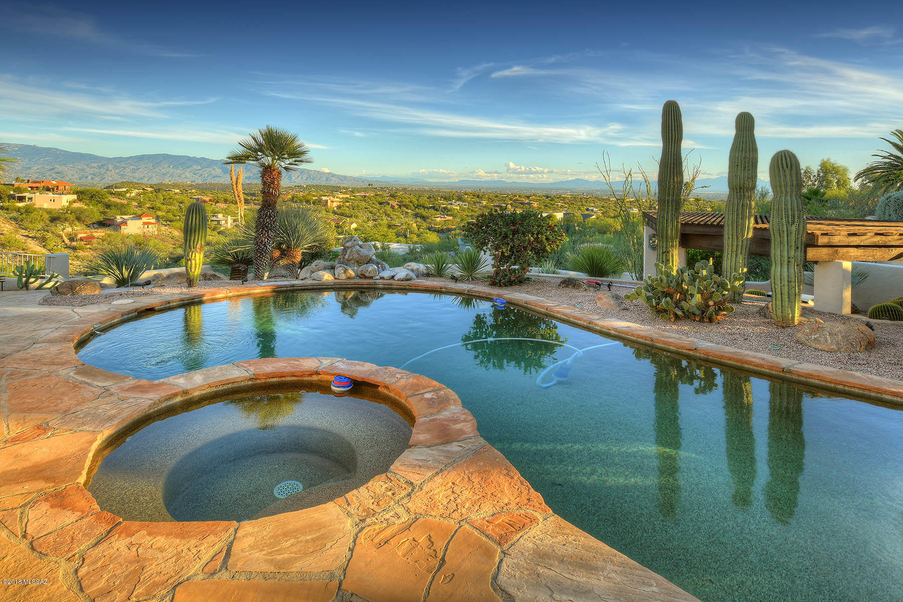 Beautiful Mediterranean home with breathtaking views of the city, mountains, canyon and valley. Ideally nestled on a quiet cul-de-sac, on a .85-acre ridgetop lot. Spacious 3,552 sq. ft. home w/ 4 bedrooms, + office and 3 full baths in the Catalina Foothills. Expansive living room with two-sided fireplace, large formal dining room, lovely gourmet eat-in kitchen w/ stainless steel appliances, granite countertops, cabinets w/ pull outs and a large pantry. Gracious master suite offers spectacular views of city lights, and is complete w/ fireplace, ensuite bathroom w/ garden tub, walk-in shower, dual vanities and walk-in closet. Spectacular backyard w/ stunning views offers year-round outdoor living and entertaining at its best – large flagstone covered patio w/ceiling fans, heated pool and s Decorative covered outdoor kitchen, waterfall, and kiva fireplace with built-in seating.  Home has many recent upgrades. Best of Foothills.