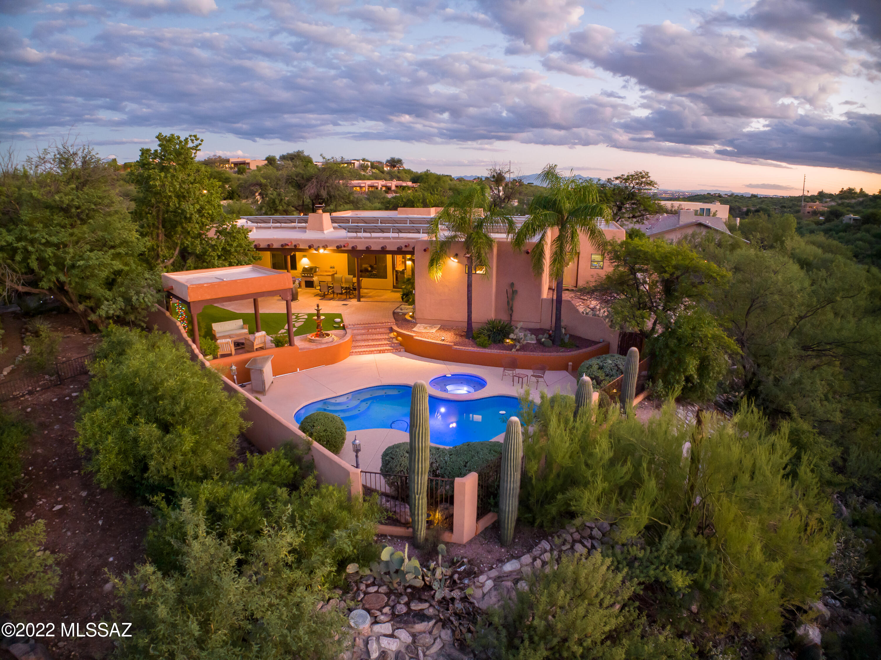 An exceptional Tucson home! This beautiful Santa Fe style property with Mexican tile throughout is located at the base of the Catalina Mountains. Breathtaking sunsets yours to enjoy regularly while relaxing in the swimming pool or under the ramada. The great room provides an ideal space for entertaining and natural light fills the space daily. A split floor plan is the perfect layout with a quiet primary suite retreat. The home features solar panels, a newly remodeled kitchen, fresh paint, unique skylight stained glass, new carpet, and a Nest thermostat. North facing, covered patio protects from sun all day long. There are minimal west facing windows, which helps to keep the heat out. Make sure not to miss the unique, multi-panel desert landscape artwork in the Great Room!