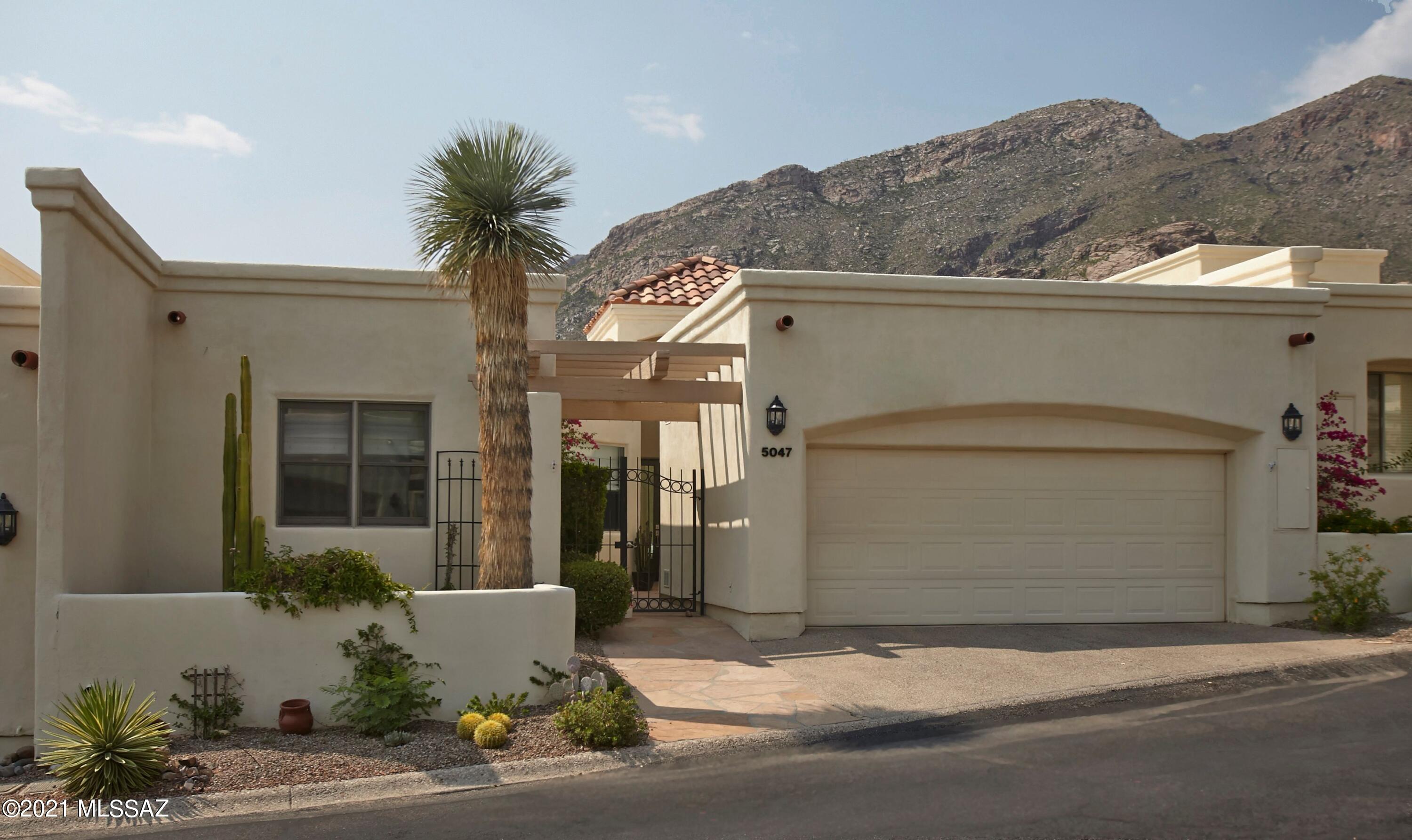 Remodeled to sophisticated contemporary perfection, this 3bed/2bath townhome in prestigious, guard gated Skyline Country Club offers an open floorplan with sky-high ceilings, quality finishes, and stylish details. The main living space features stunning 24x24 Italian floor tile, custom concrete fireplace, and wall of windows to marvel at the Catalina Mountain views.  Designer kitchen with all new sleek cabinetry, GE Profile appliances, and leathered granite  countertops. The spacious Owner's suite features a unique privacy wall creating a comfortable sitting area. Spa-like bathroom with enormous tiled shower, dual vanities with vessel sinks, plentiful storage and custom closet. Split floorplan with 2 additional bedrooms and a remodeled guest bathroom. Enjoy the outdoor living space with exquisite mountain views, common area green space and no neighbors directly behind. New HVAC, all solid core walnut doors, new window coverings, and all new light fixtures. Peaceful, quiet, and perfect as either a primary residence or part time "lock and leave" retreat.