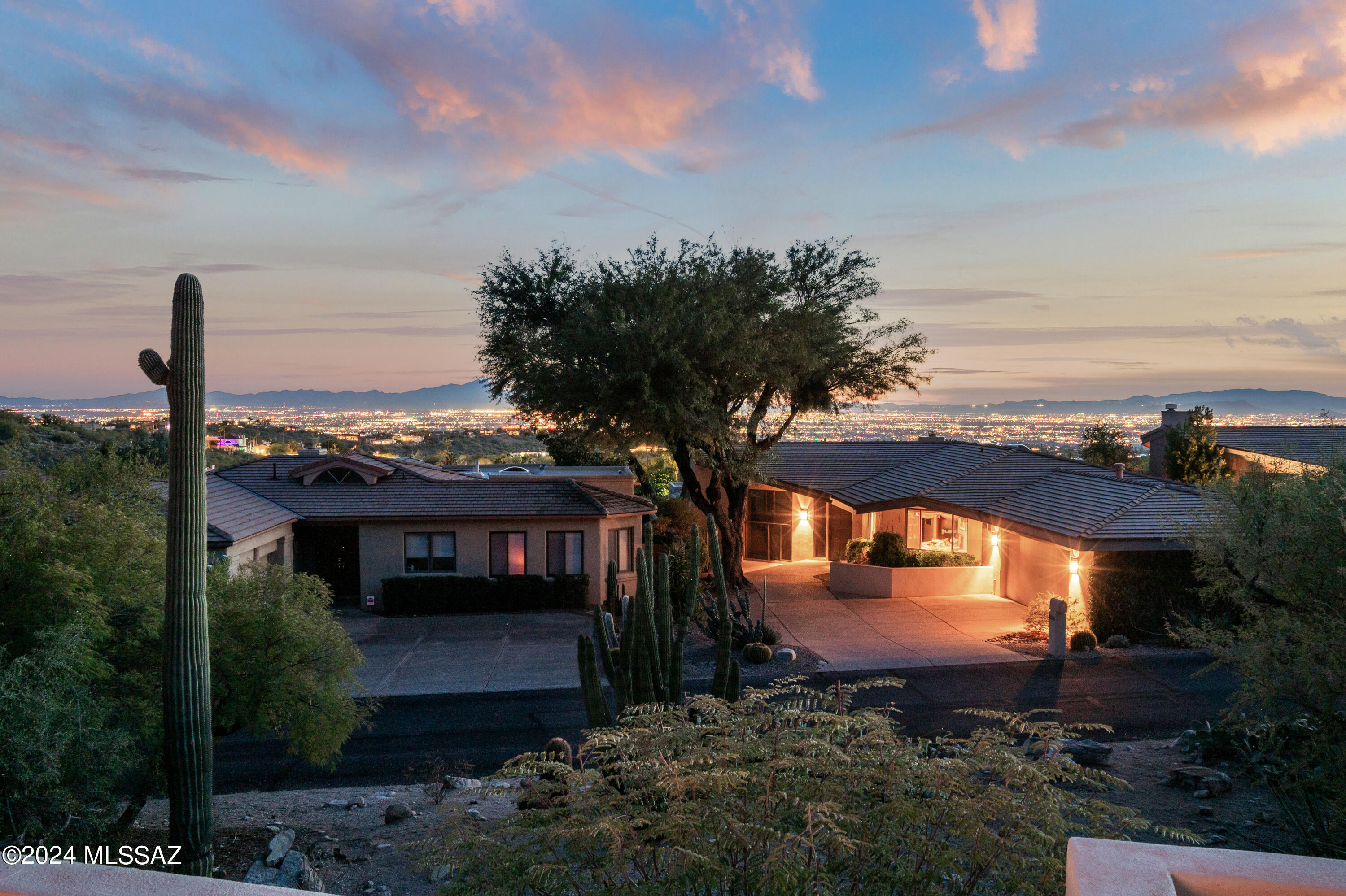 City & Mountain views in the  manned and gated community of  Finisterra II.  3Bd, 2 & 3/4 bath. Contemporary w gorgeous bamboo wood floors, ceramic tile, lots of windows, large kitchen, walk in pantry, stainless steel appliances. Large living room  with floor to ceiling windows provides city views, lots of niches, large master suite, jacuzzi tub, large walk in closet. Washer & dryer in Laundry Rm. Split bdrm plan , extended length garage, wall to wall storage. Inviting front patio with wrought iron fencing & mountain views,. A rear patio for entertaining and views of the city lights  and large specimen cacti in area below that is part of your lot. Lovely Clubhouse with tennis courts, pool, etc.  Hiking trails, Lowes Ventana Resort and Tram rides nearby. Guarded entry 24 hrs a day. Go Show