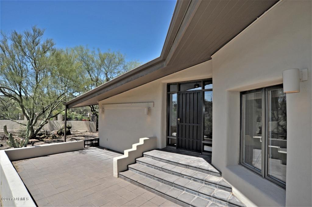 Contemporary 1978 custom mud adobe home in the heart of the old Foothills. This 2 bedroom 3 bath gem is carefully hidden on 2.5 Acres with views of the Catalina Mountains that don’t stop from every room of the house! Interior concrete tiles add character and charm. Enjoy a cozy fire in your open living area with separate reading room/den. Master suite with his and hers baths and closets with optional sitting room or office space. Four patios to choose from to sit outside and enjoy your private desert oasis. Newly remodeled kitchen with a built-in breakfast table placed strategically in front of a wall of windows to bring the outdoors in. Plenty of storage in your large garage with a spacious workshop area off the laundry room.