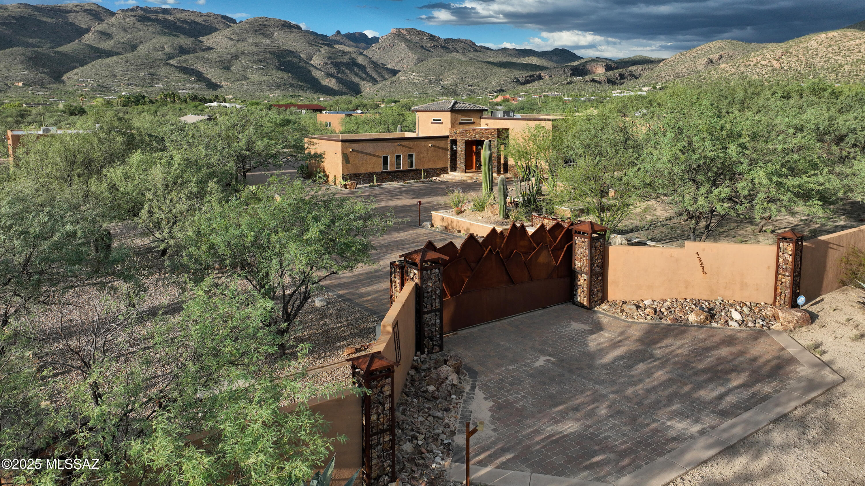 Directly across from Tucson's iconic Agua Caliente Park, this exceptional custom estate sits on over 3 walled acres with breathtaking mountain views and unmatched privacy. Thoughtfully designed, the main home showcases a wood-burning fireplace beside a built-in entertainment center with surround sound, chipped-edge granite throughout, engineered wood floors, travertine walk-in showers, Venetian plaster walls, and custom lighting with chandeliers. The chef's kitchen boasts a large island, alder cabinets, and high-end professional stainless appliances, including a 64'' refrigerator. The primary suite offers a spa-like bath with jacuzzi, custom shower, and a walk-in closet. Additional highlights include 8' alder doors, European toilets, custom hardware & owned solar panels. Amazing Views!! The home features a spacious 3-car garage, and a large back patio with a Kiva fireplace. Also an oversized 2-car garage with workshop provides ample storage. Completing the estate is a stunning masonry stucco guest house built in 2020, featuring 2 bedrooms, 2 bathrooms, concrete floors, custom tile backsplash, gorgeous views, and plenty of RV and toy parking. A true Tanque Verde Valley treasure! Both homes are available fully furnished!